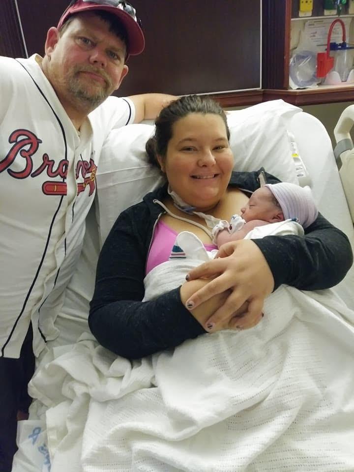 A man and woman holding a baby