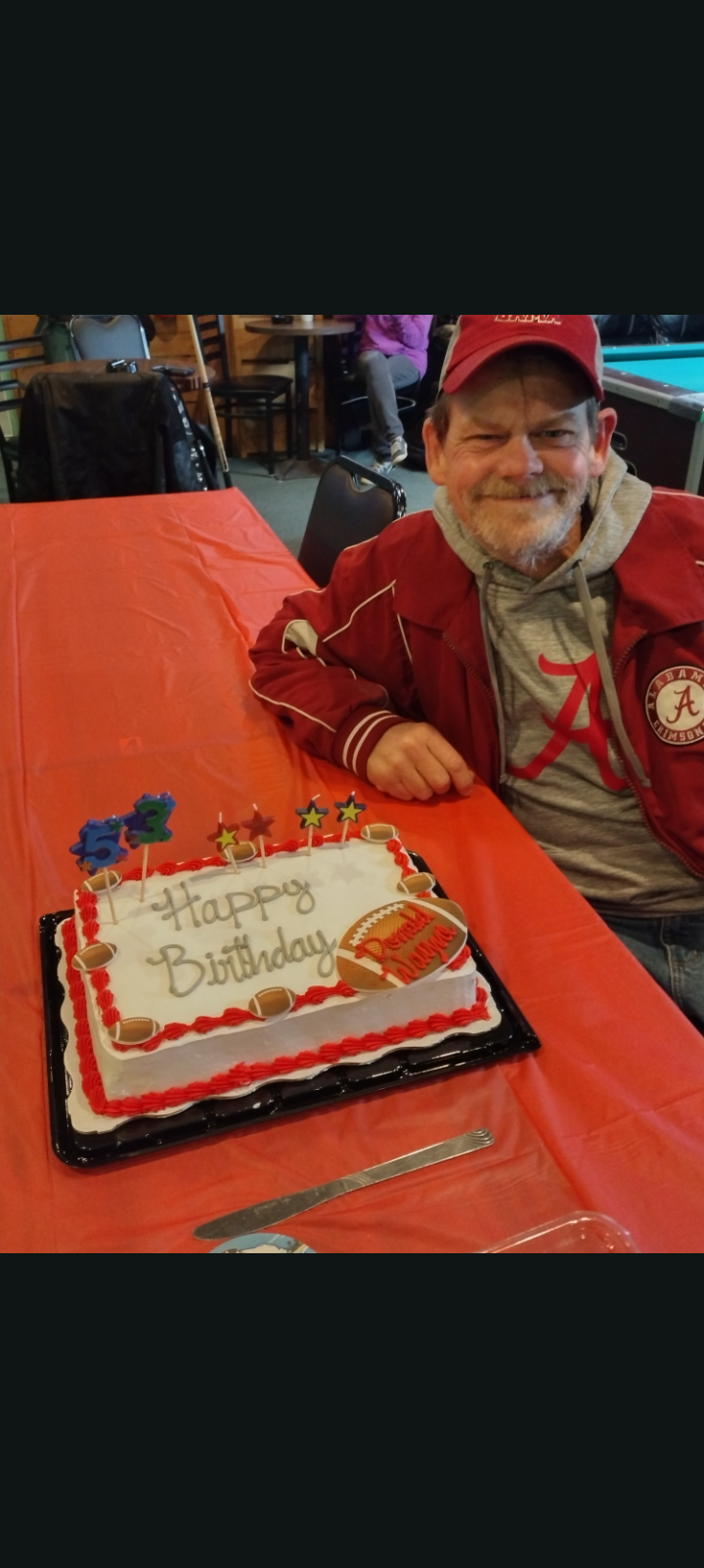 A man sitting at a table with a cake