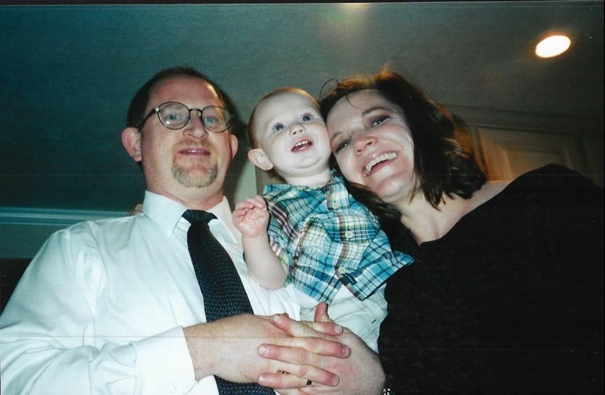 A man and woman holding a baby