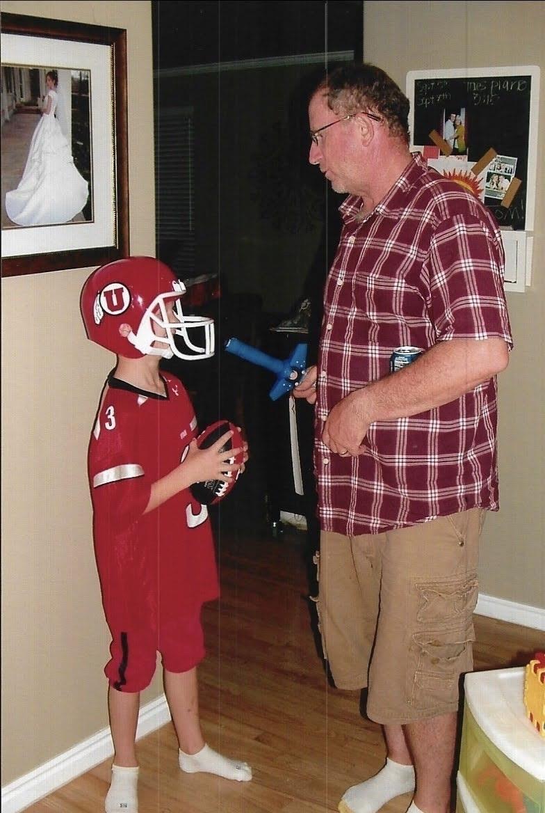 A man and boy wearing football helmets
