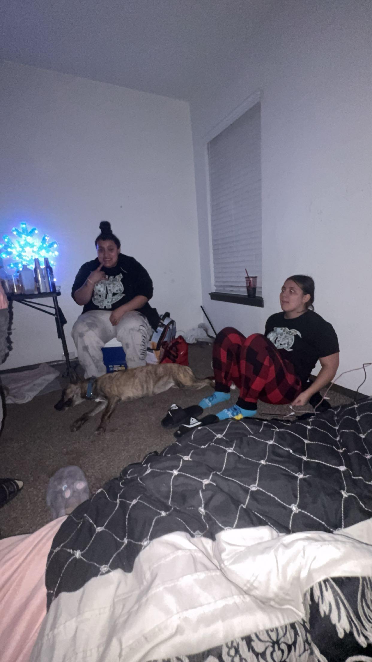 Two women sitting on the floor with a dog
