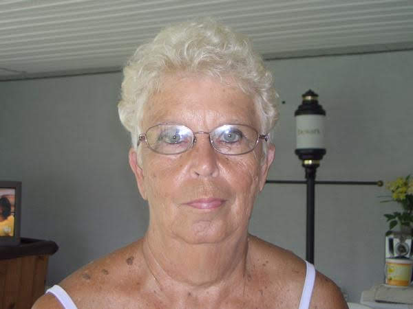 A woman with white hair and glasses