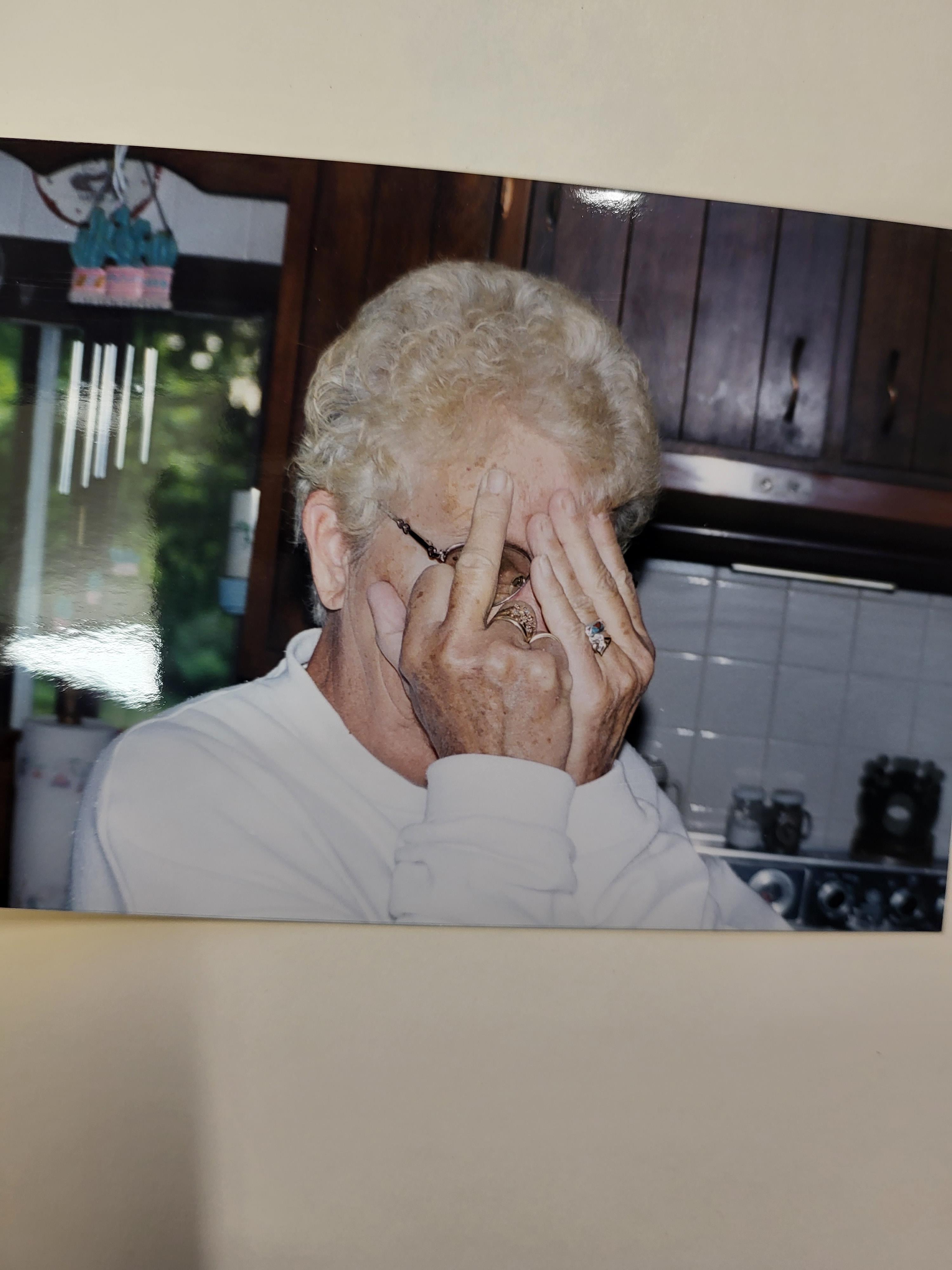 An old woman covering her face with her hands