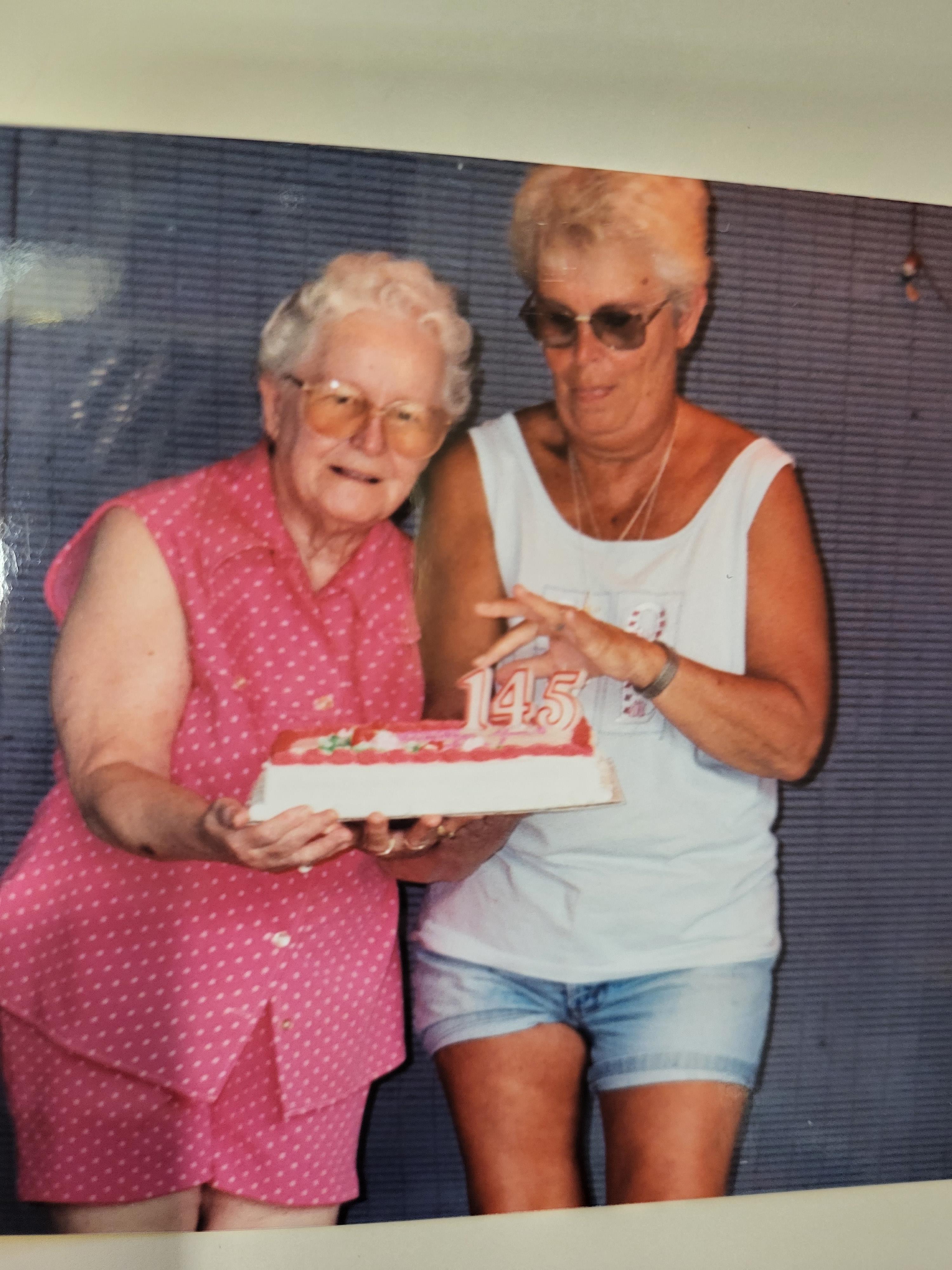 Two women holding a cake