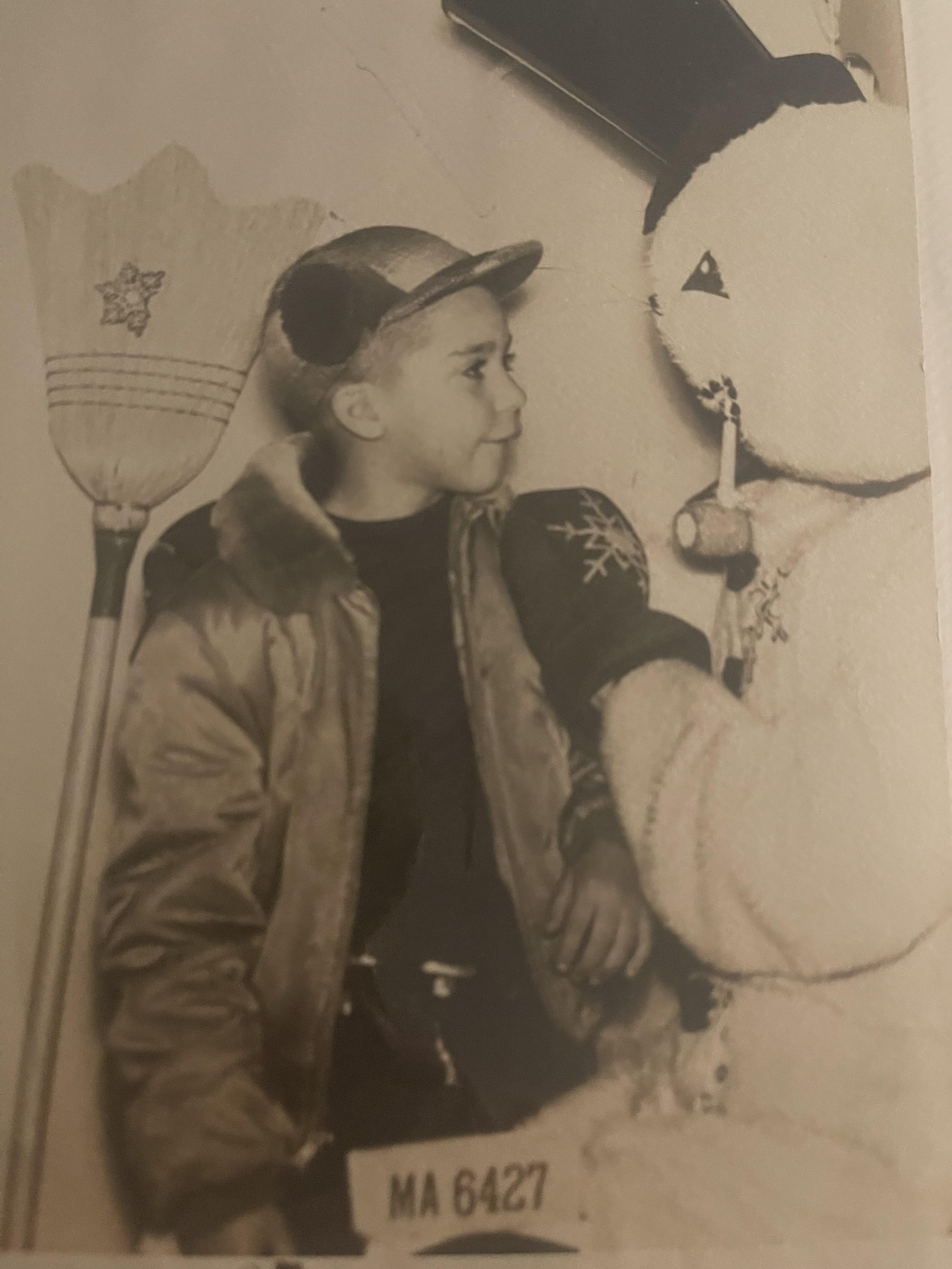 A boy standing next to a stuffed animal