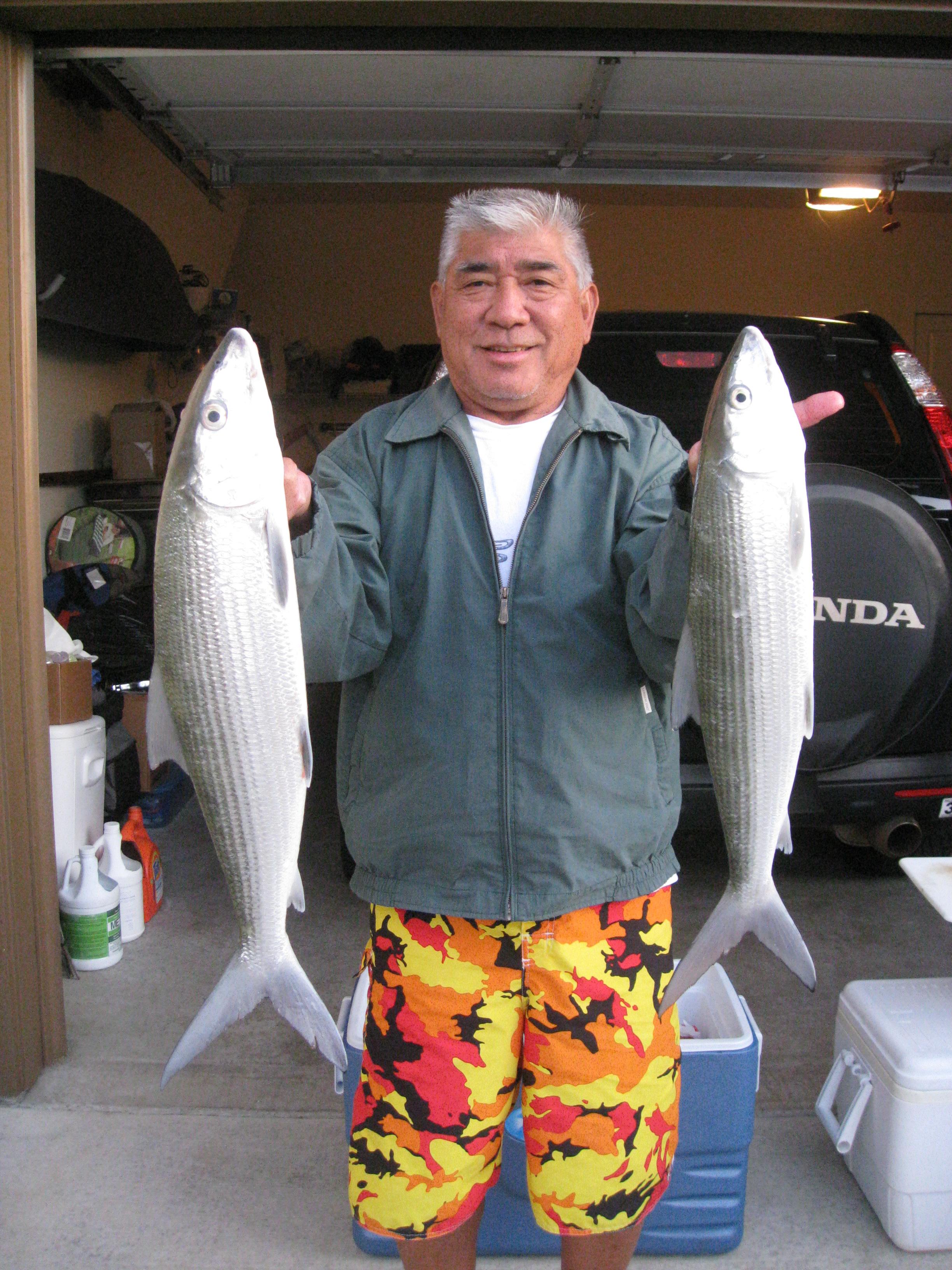 A man holding two fish