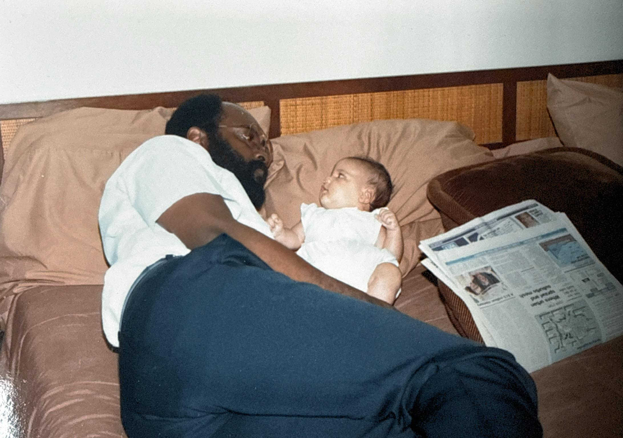 A man lying on a bed with a baby
