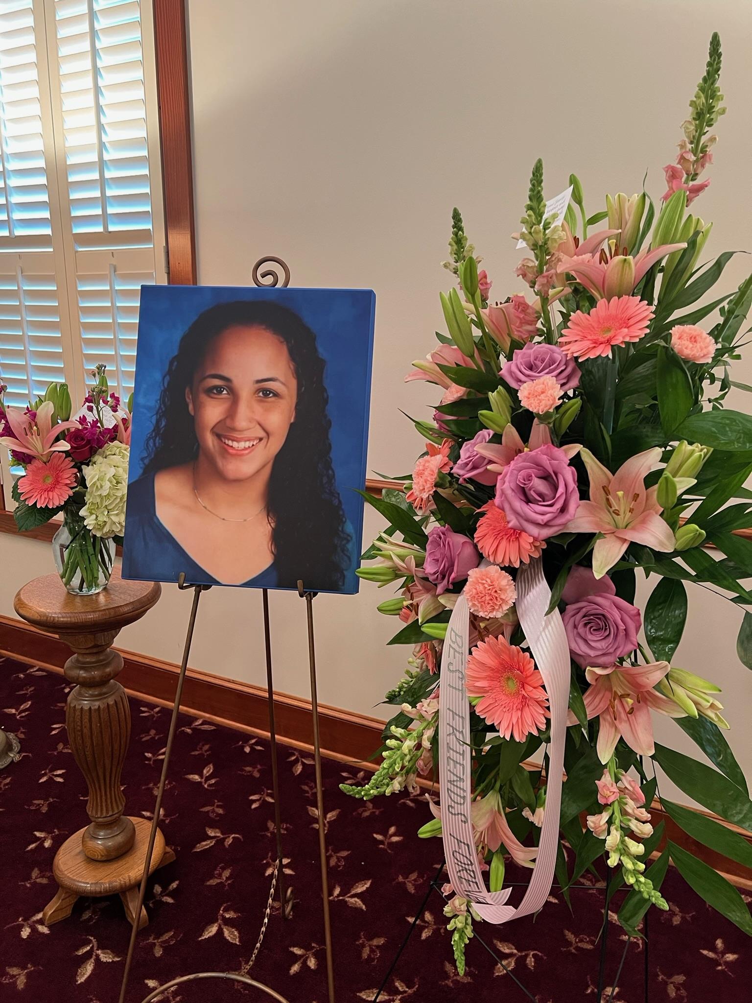 A picture of a woman in front of a bouquet of flowers