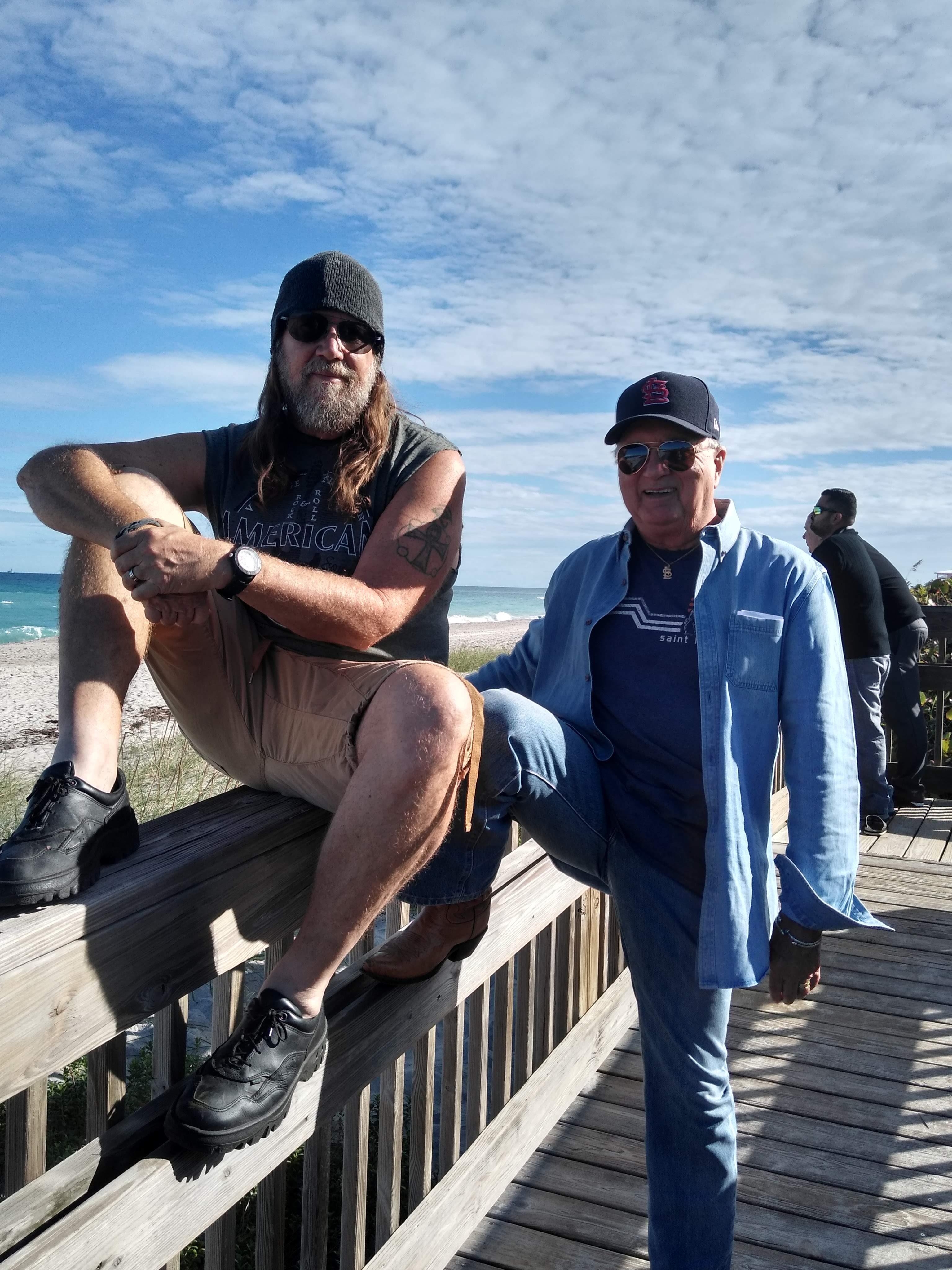 Two men sitting on a wooden railing