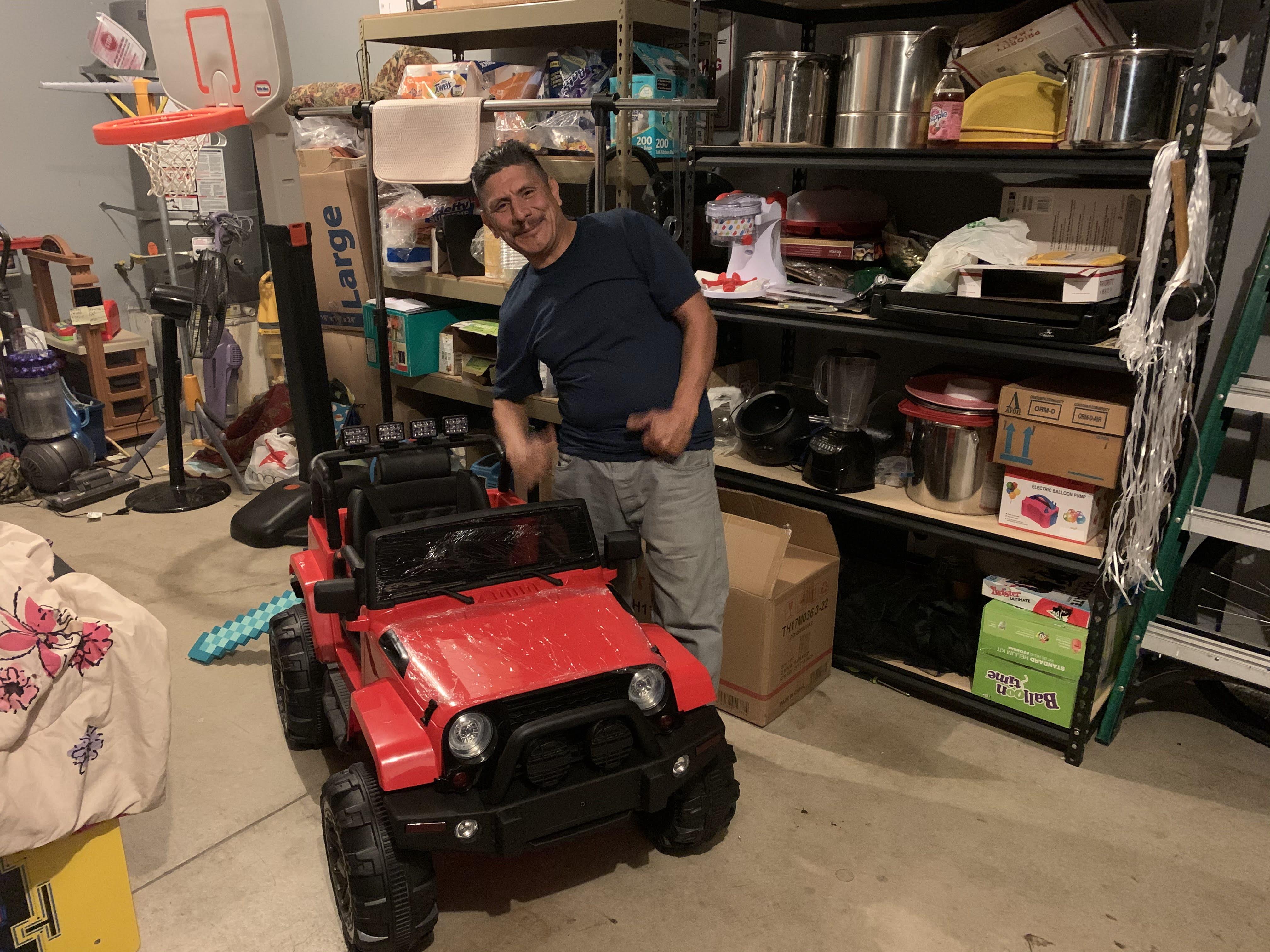A man standing next to a toy car