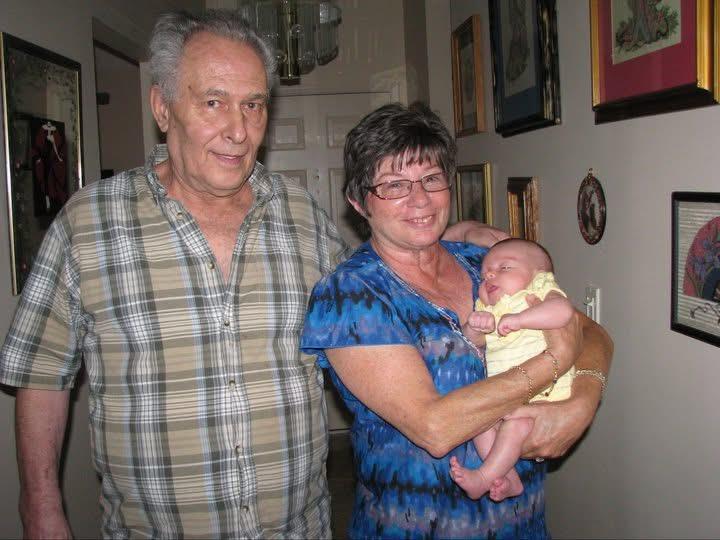 A man and woman holding a baby