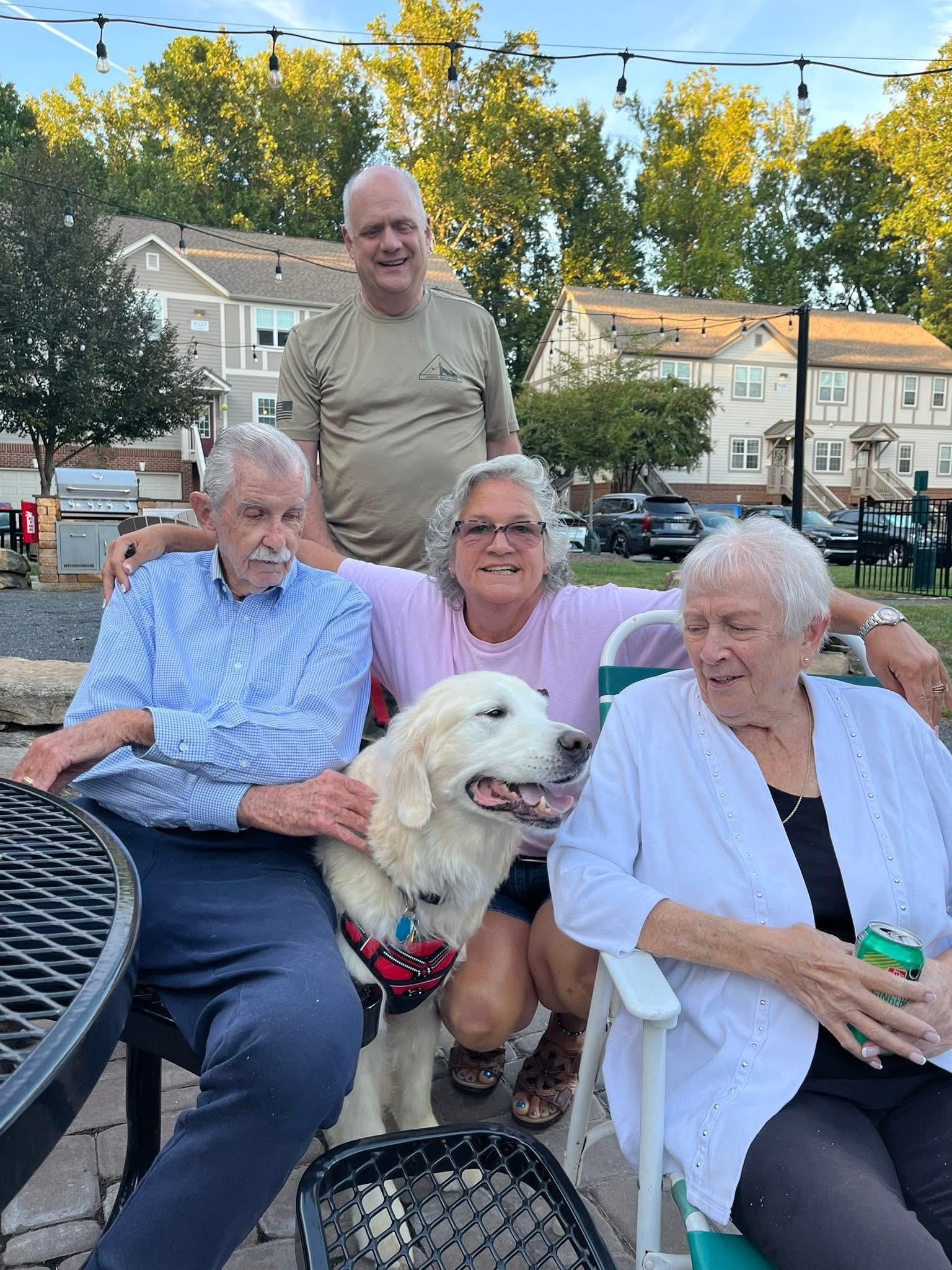 A group of people sitting in chairs with a dog