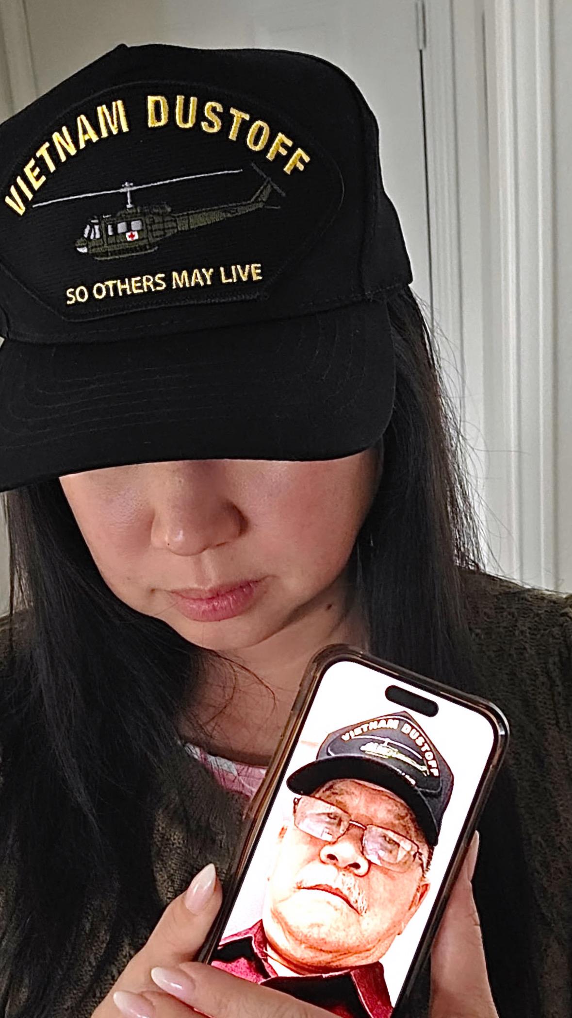 A woman wearing a hat and holding a phone case