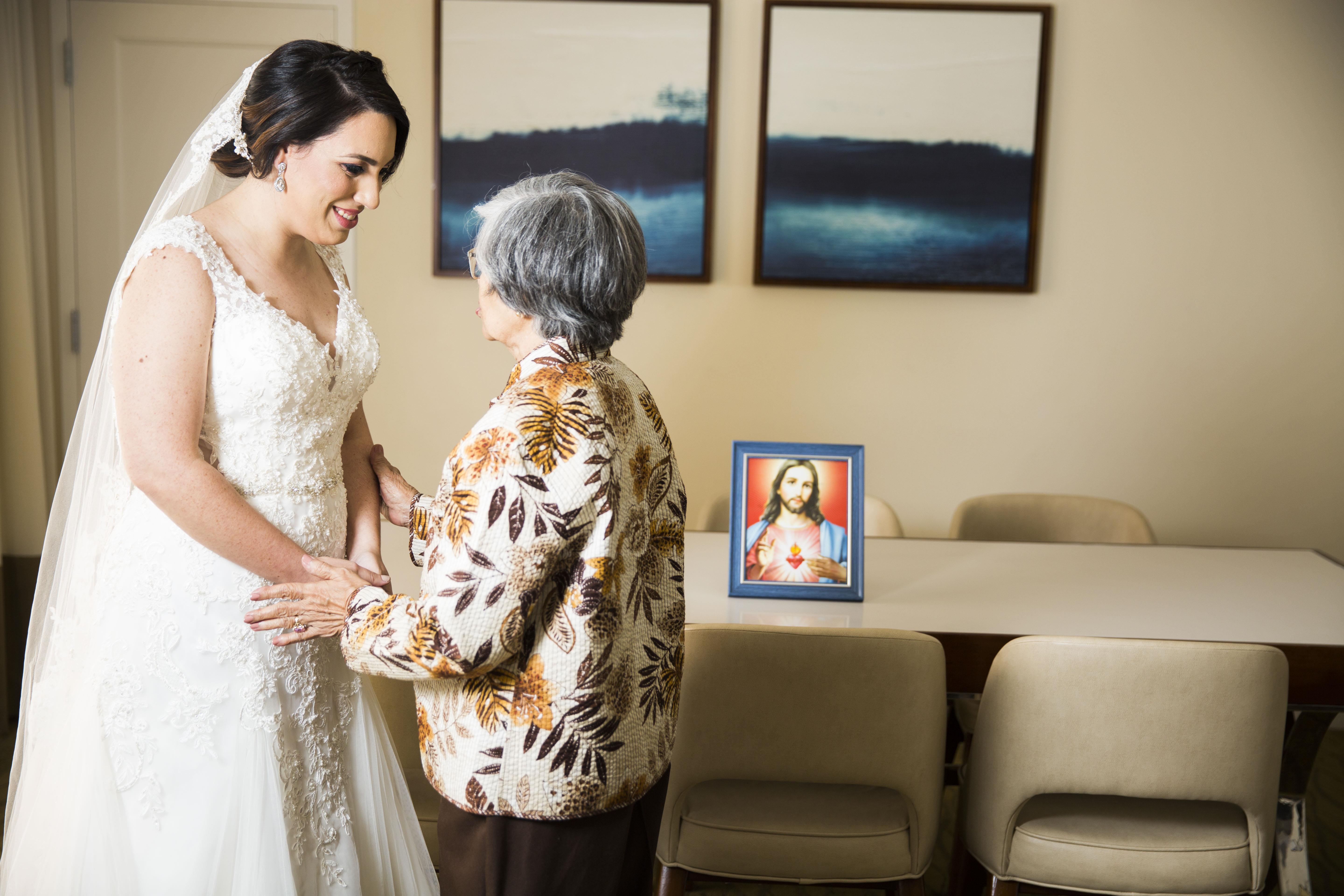 A woman in a wedding dress standing next to an elderly woman