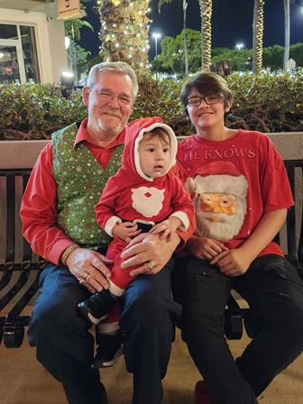 A man and woman sitting on a bench with a baby