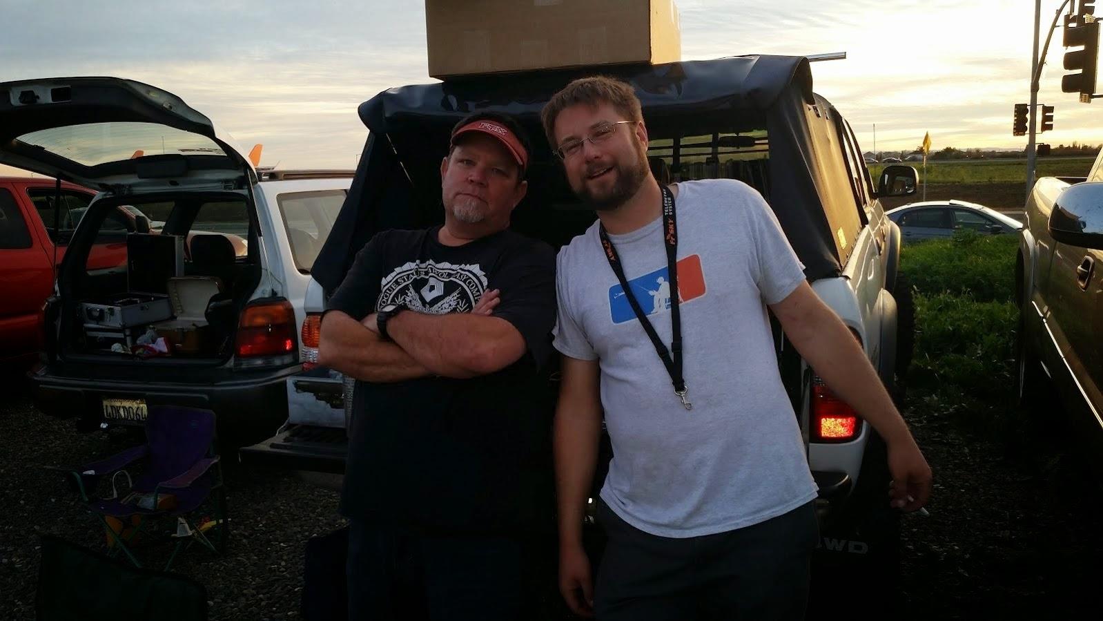 Two men standing next to each other in the back of a truck