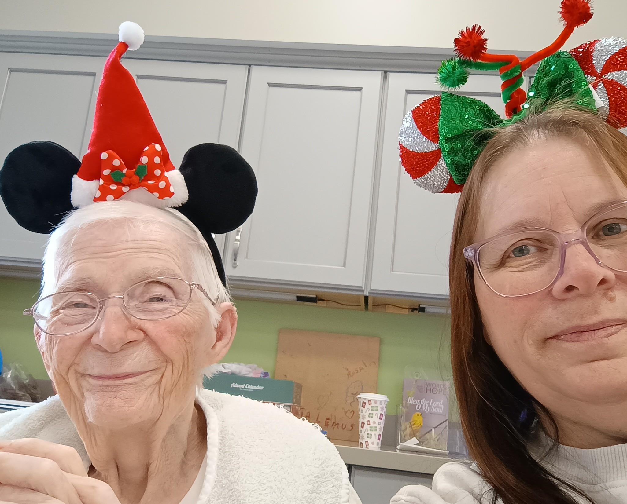 A woman and a woman wearing christmas hats