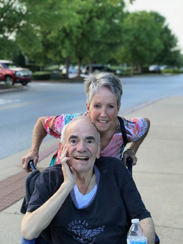 A man pushing a woman in a wheelbarrow