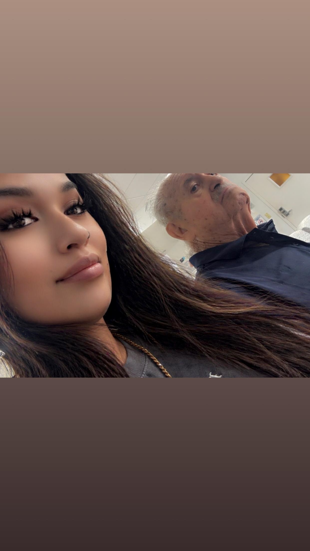 A woman taking a selfie with an old man