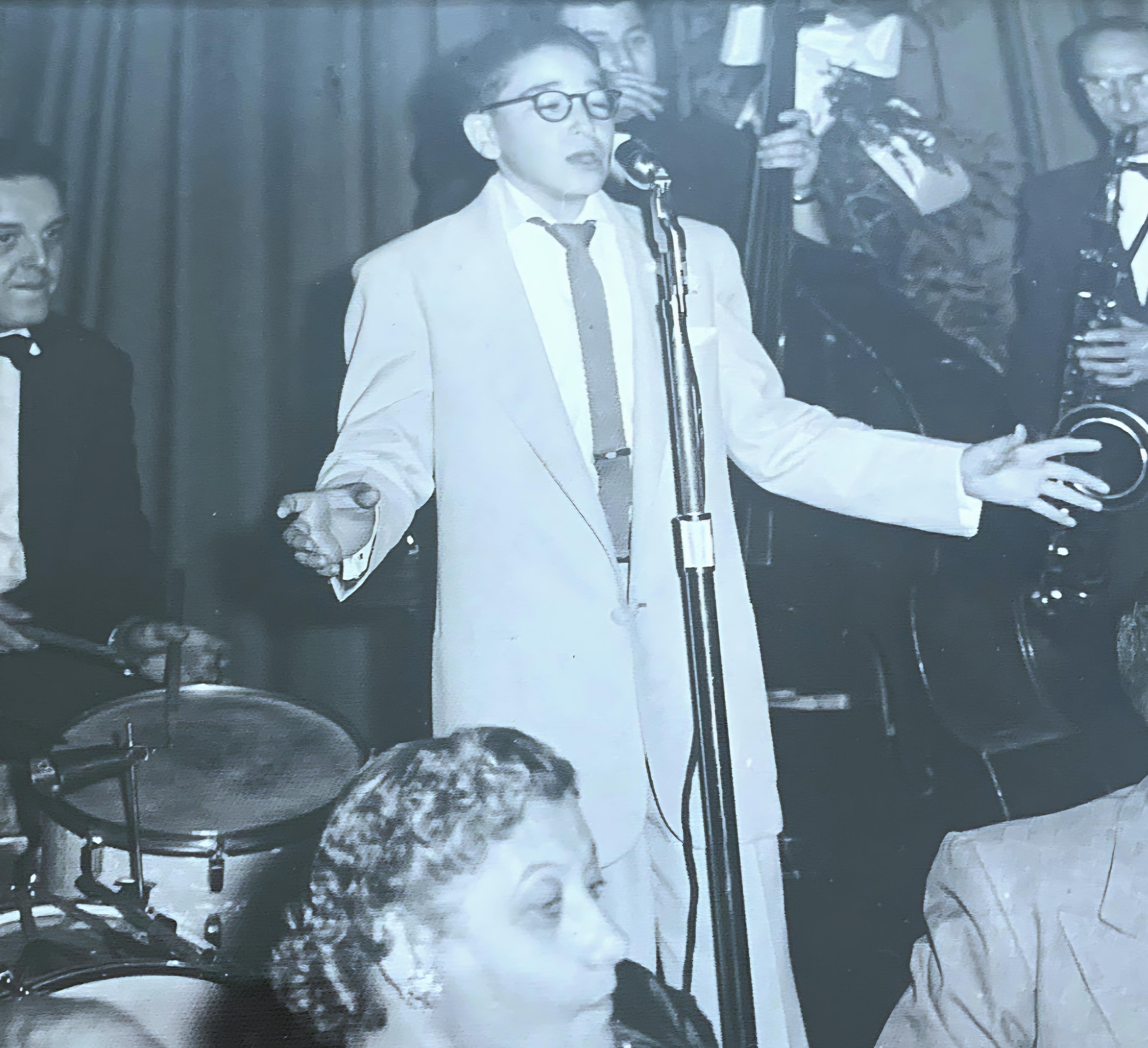 A man in a suit singing into a microphone