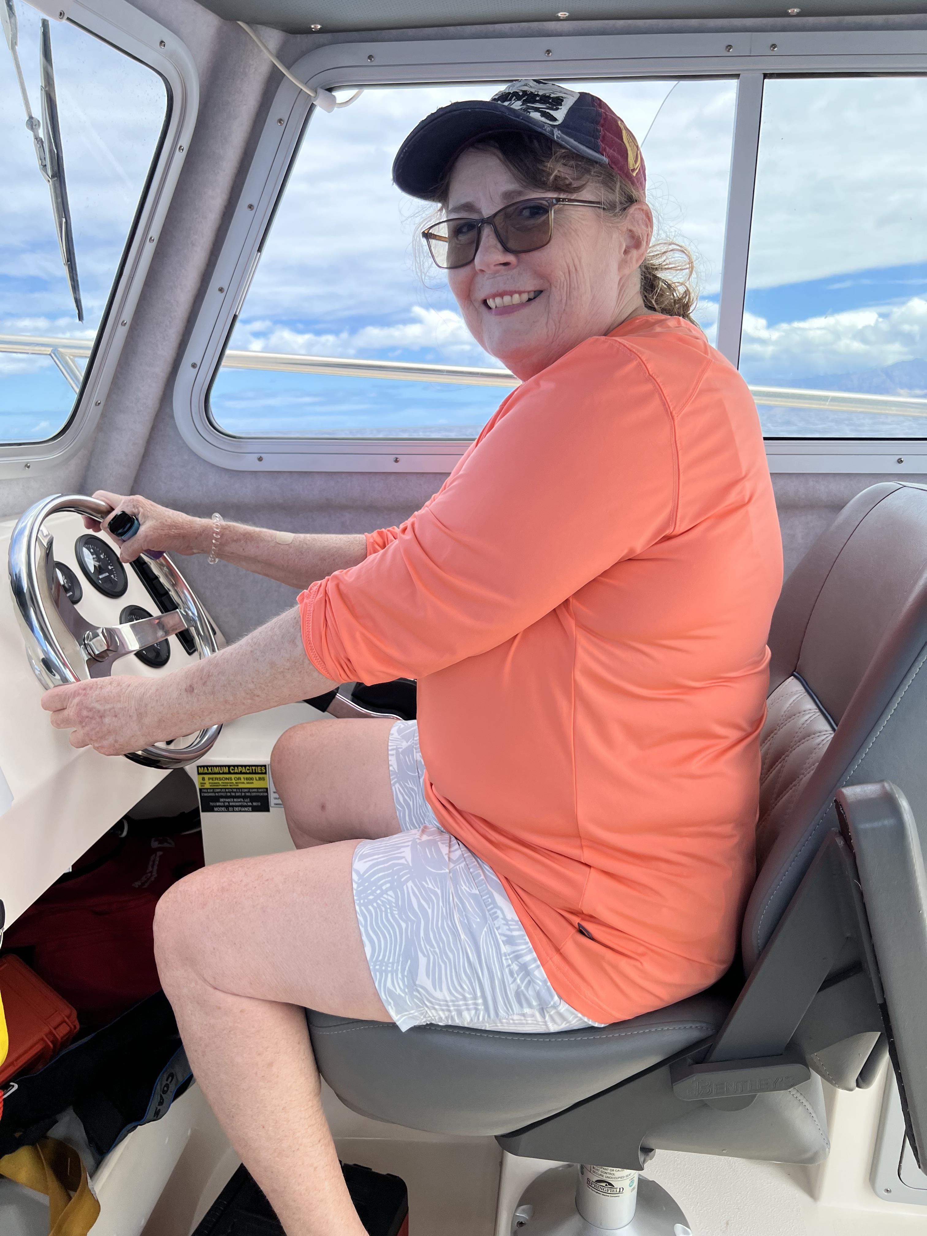 A woman in a hat driving a boat