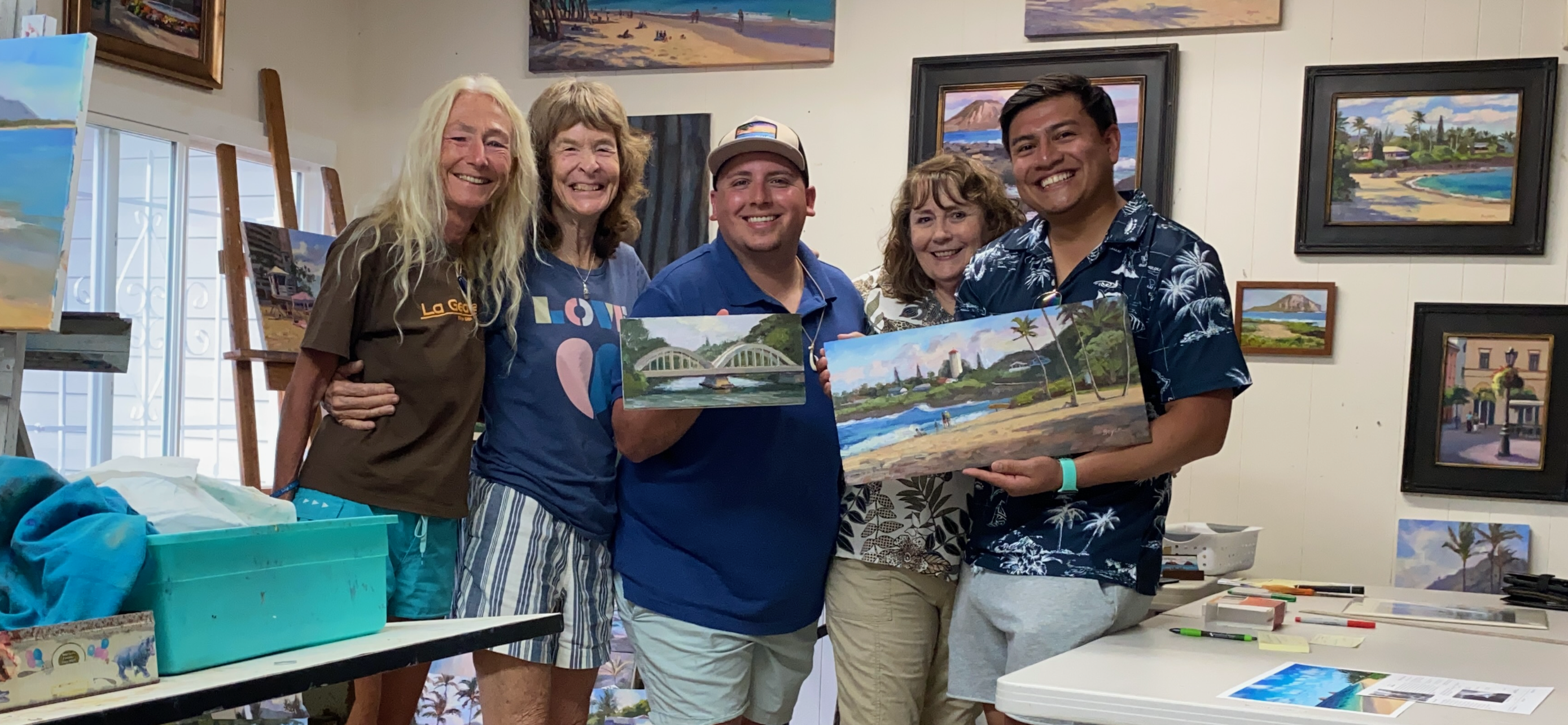 A group of people holding up paintings