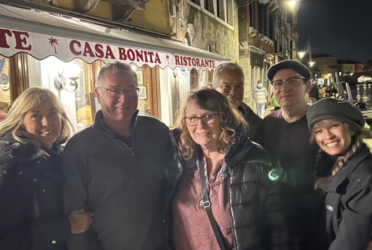 A group of people standing in front of a restaurant