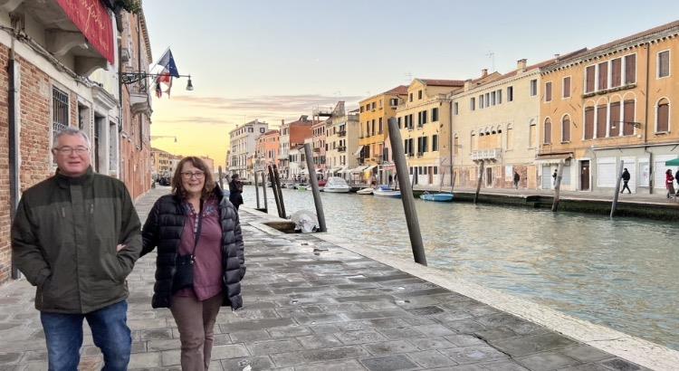 A woman walking on a sidewalk next to a body of water