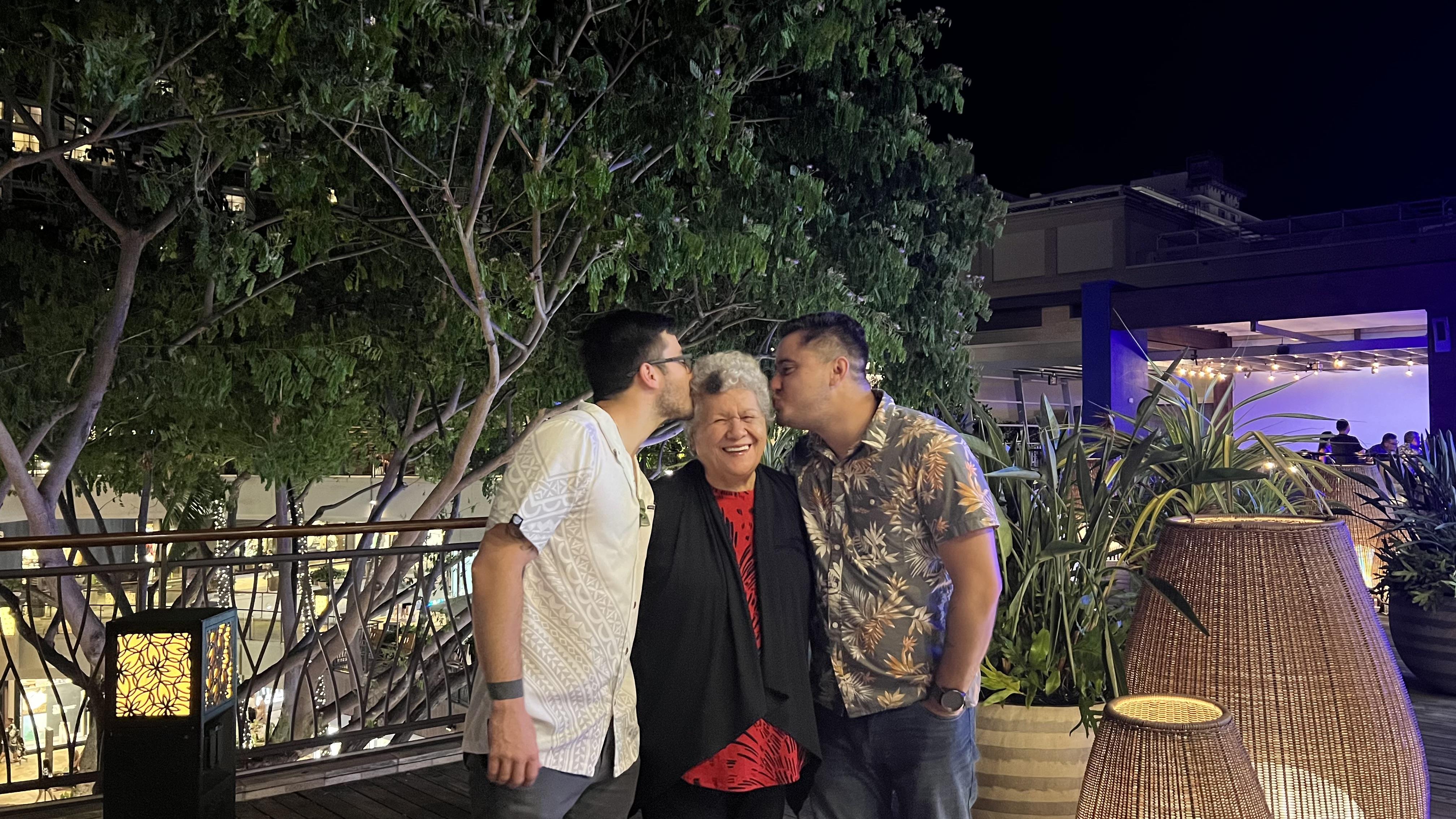 A group of people kissing a woman