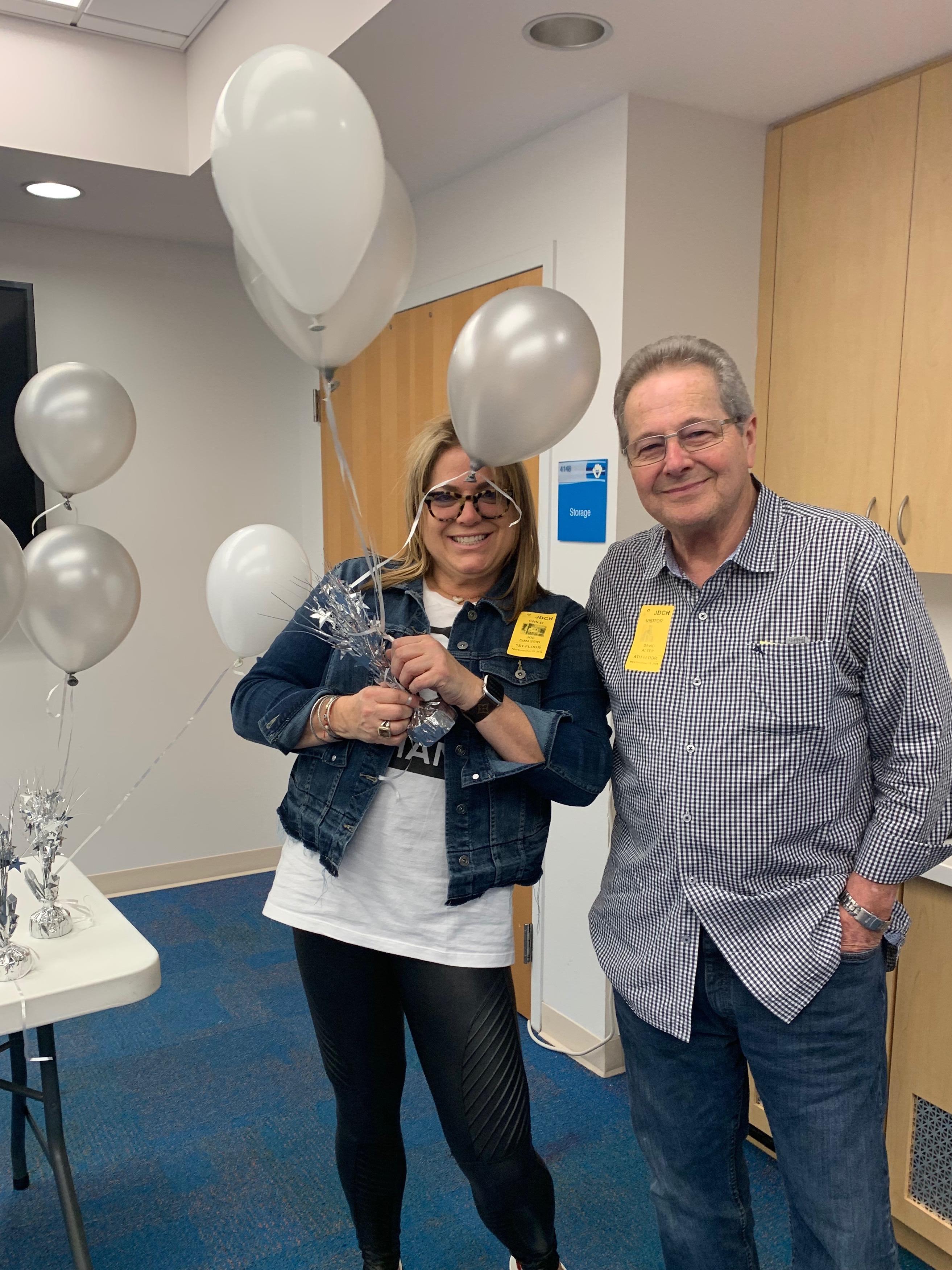 A man and woman holding balloons