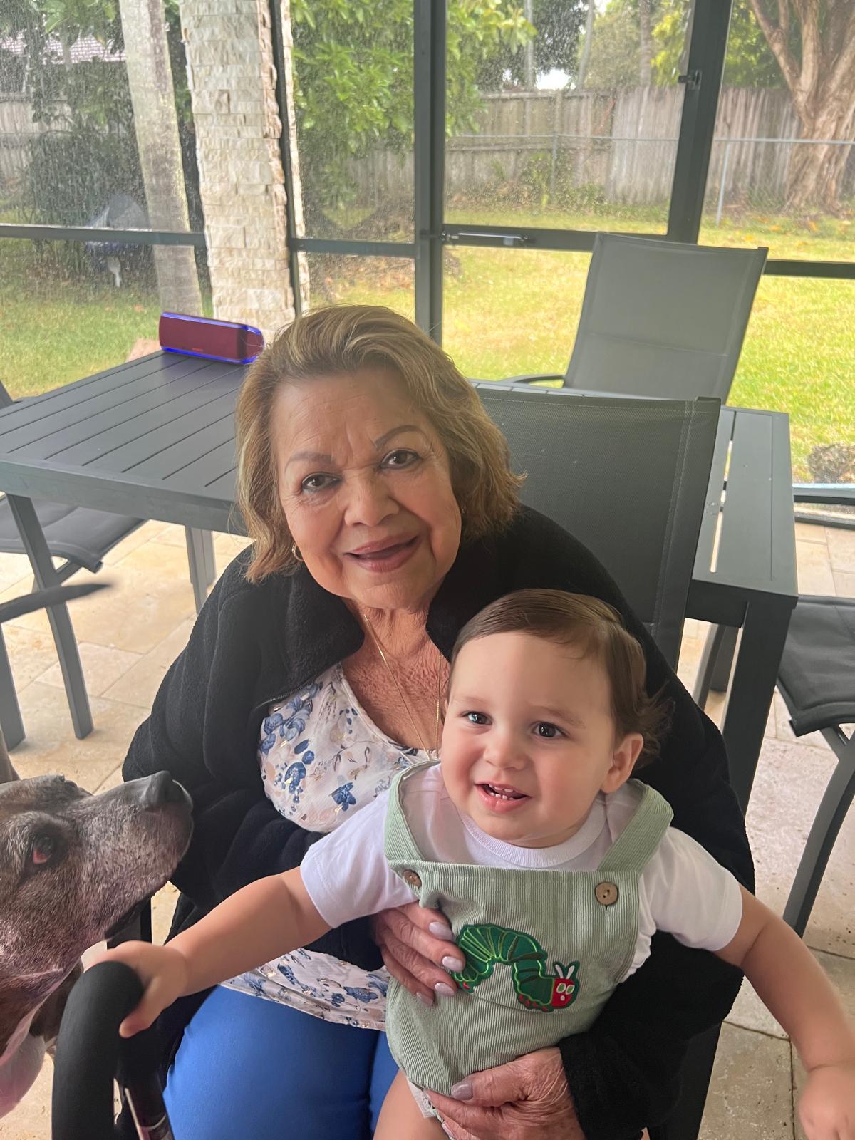 A woman holding a baby and a dog