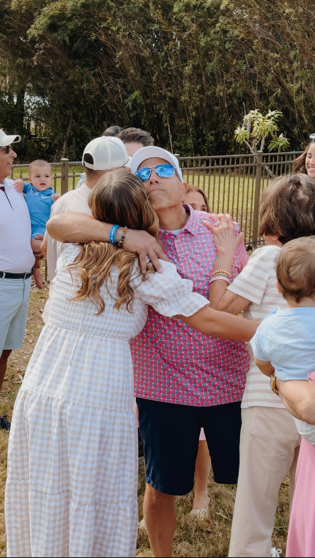 A man and woman hugging in front of a group of people