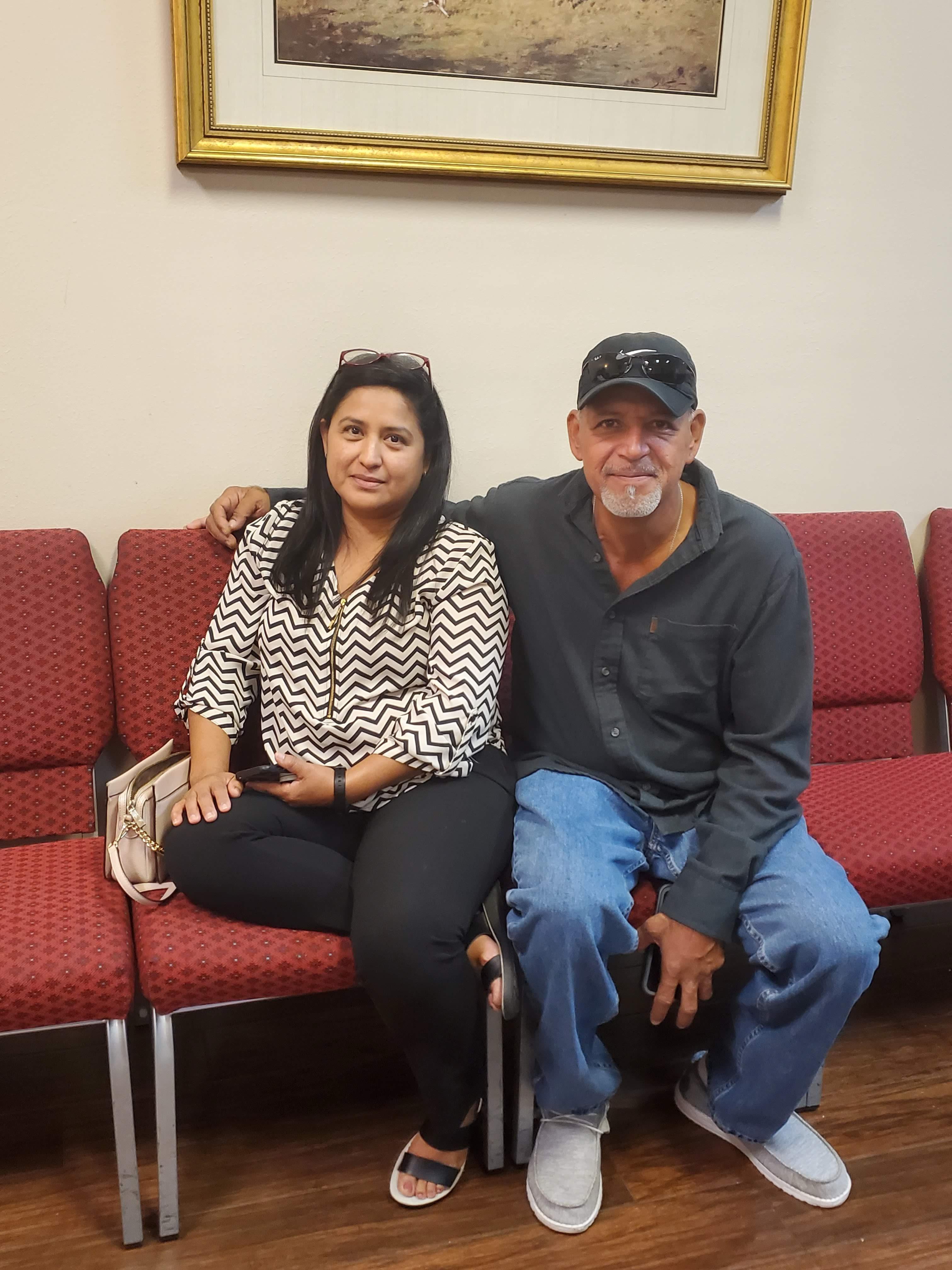 A man and woman sitting on a red bench