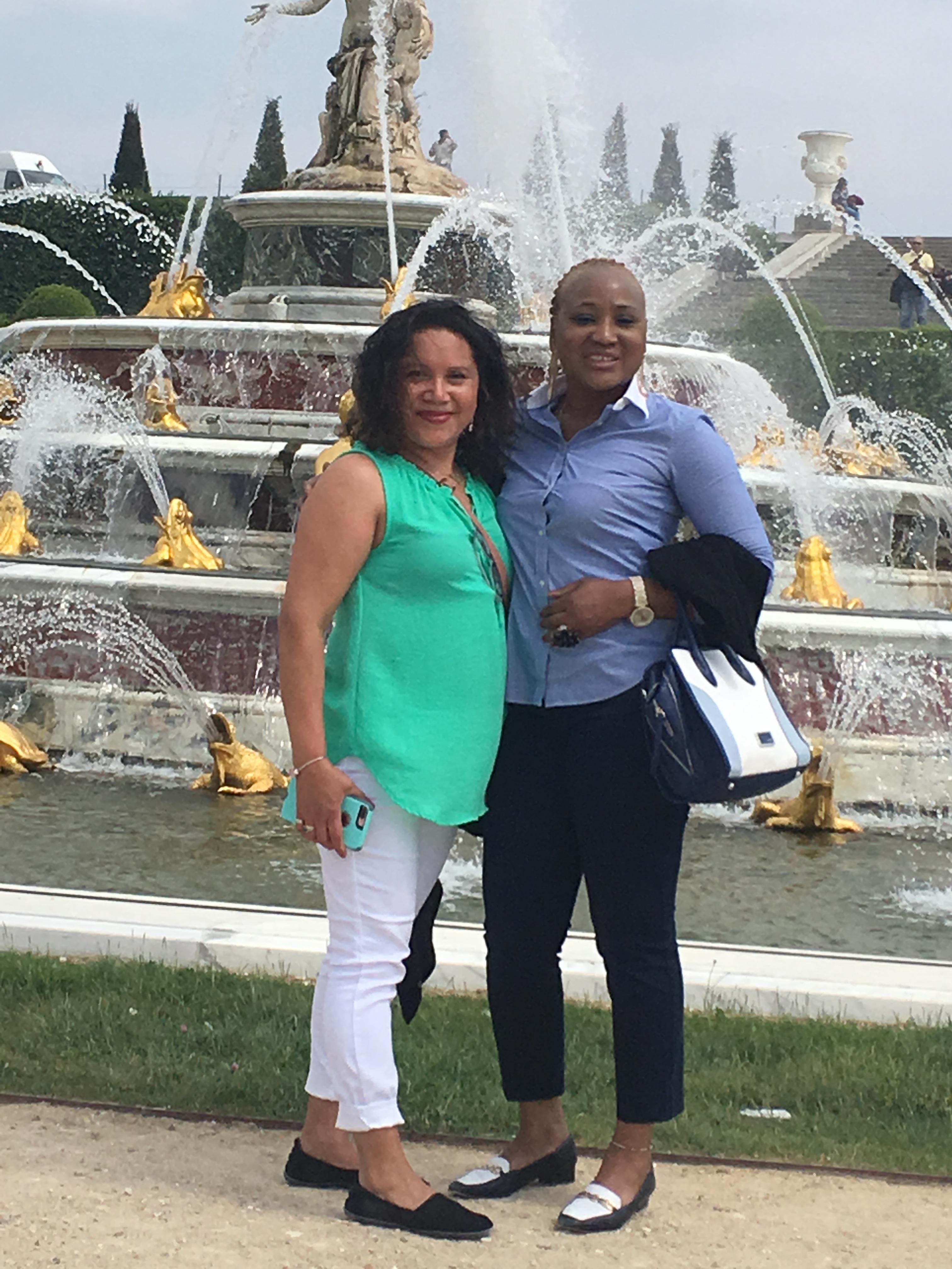Two women standing in front of a fountain