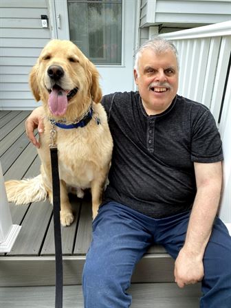 A man sitting next to a dog