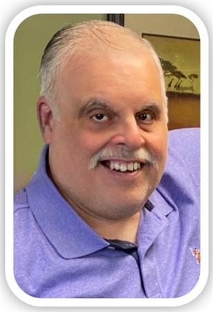 A man with a mustache smiling
