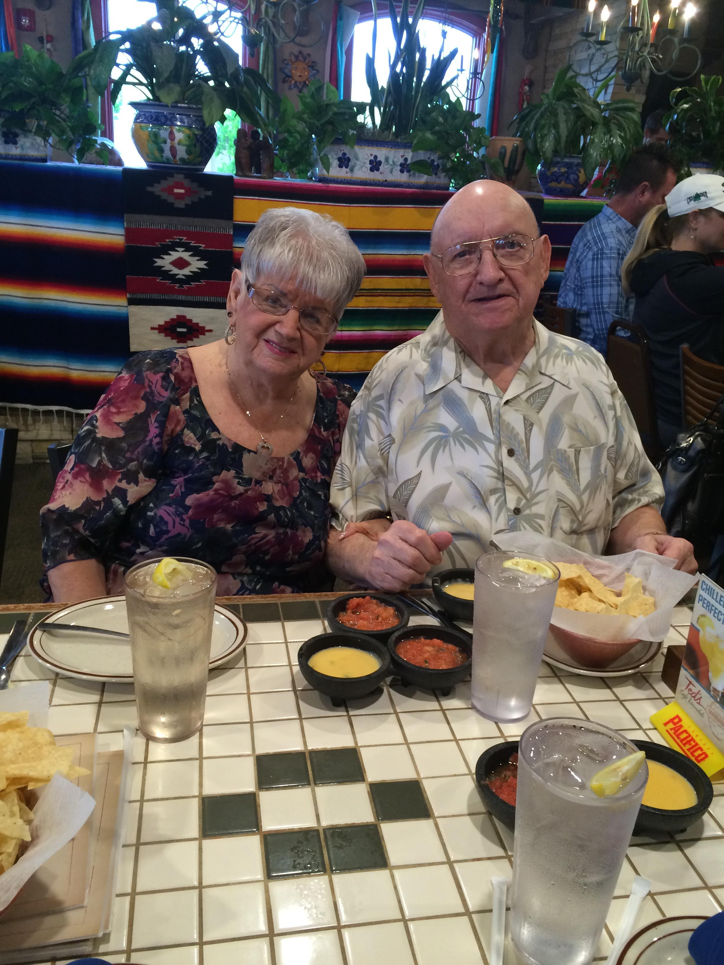A man and woman sitting at a table with food