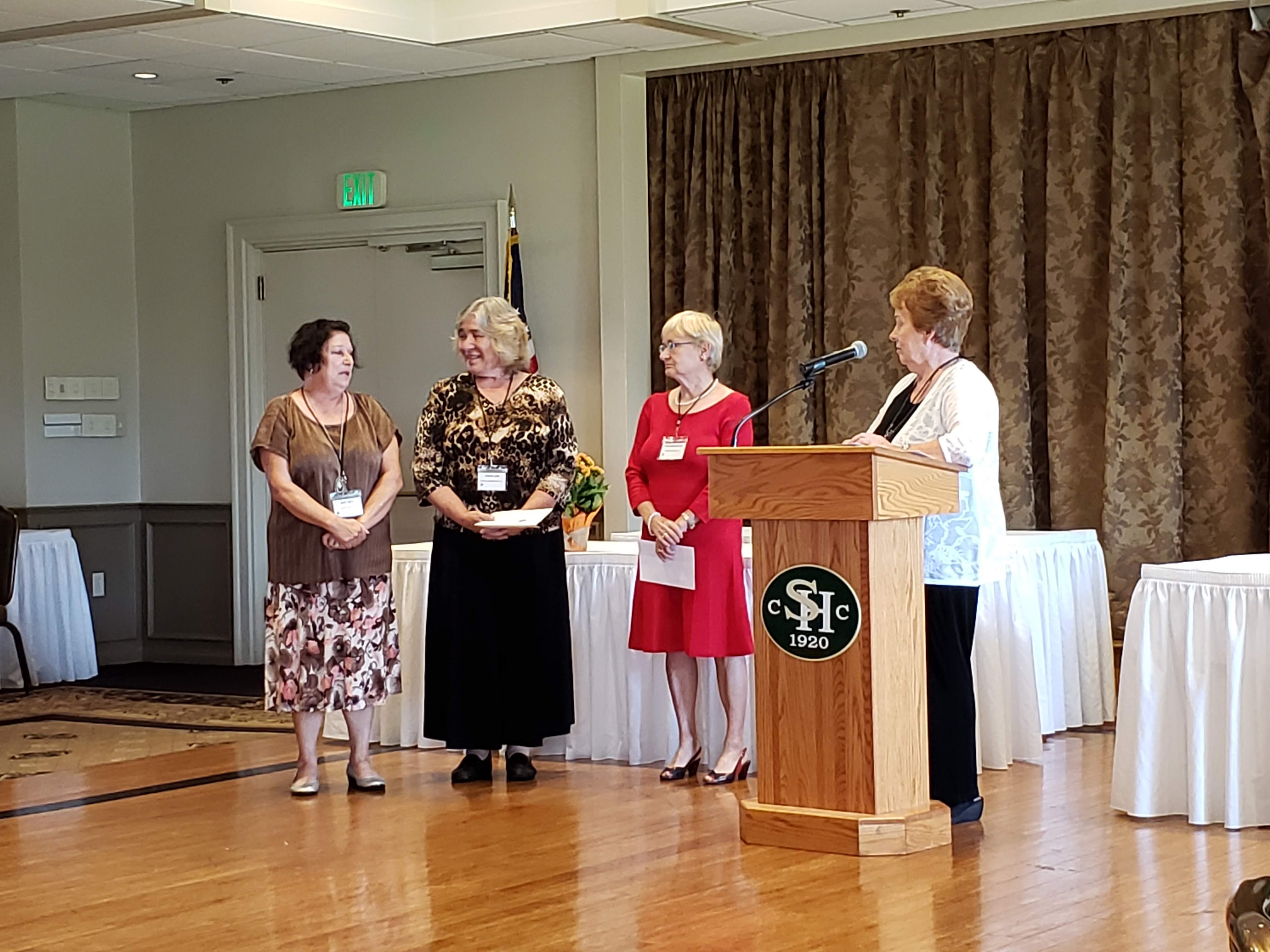A group of women standing at a podium