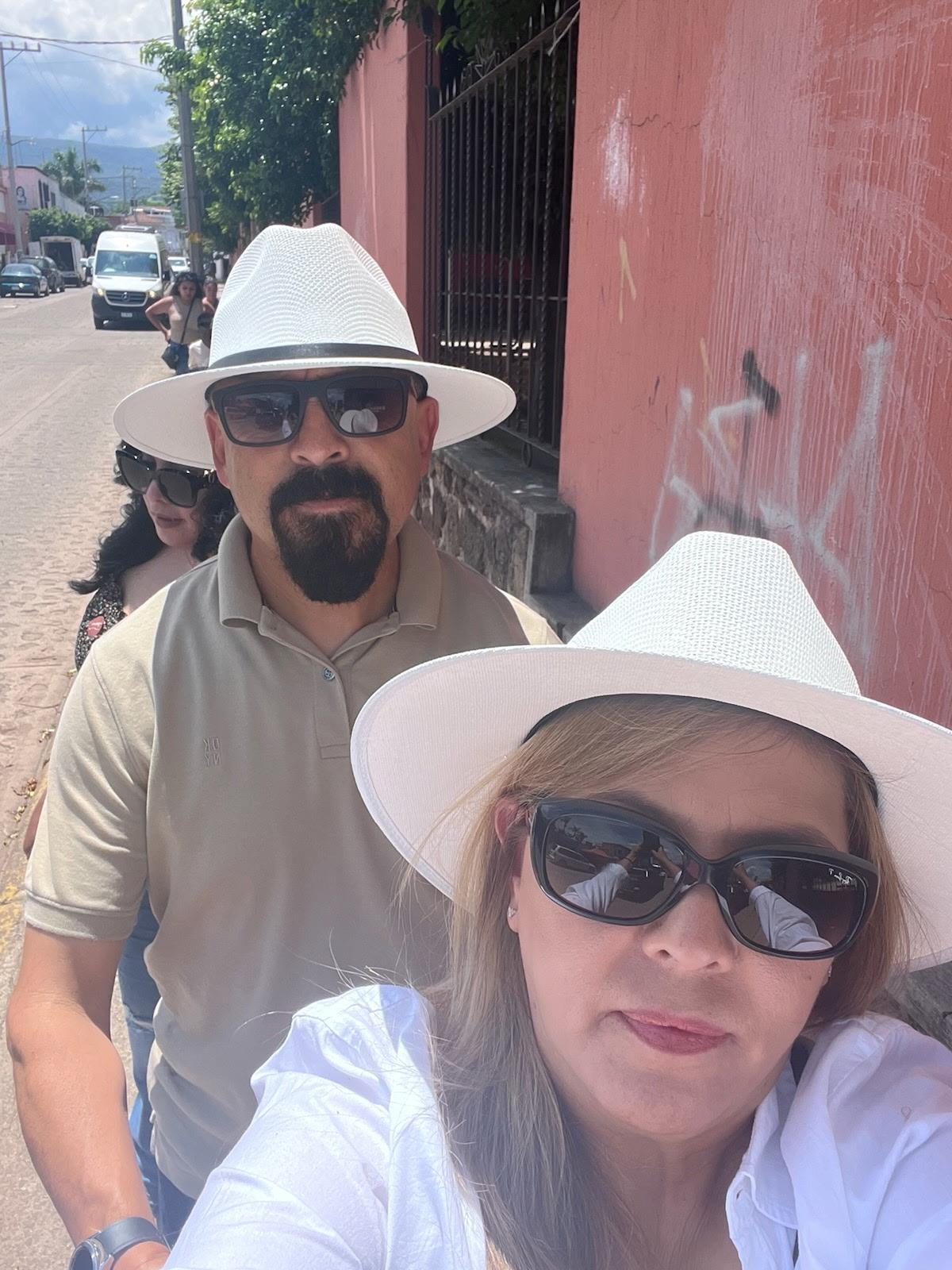 A group of people wearing white hats and sunglasses