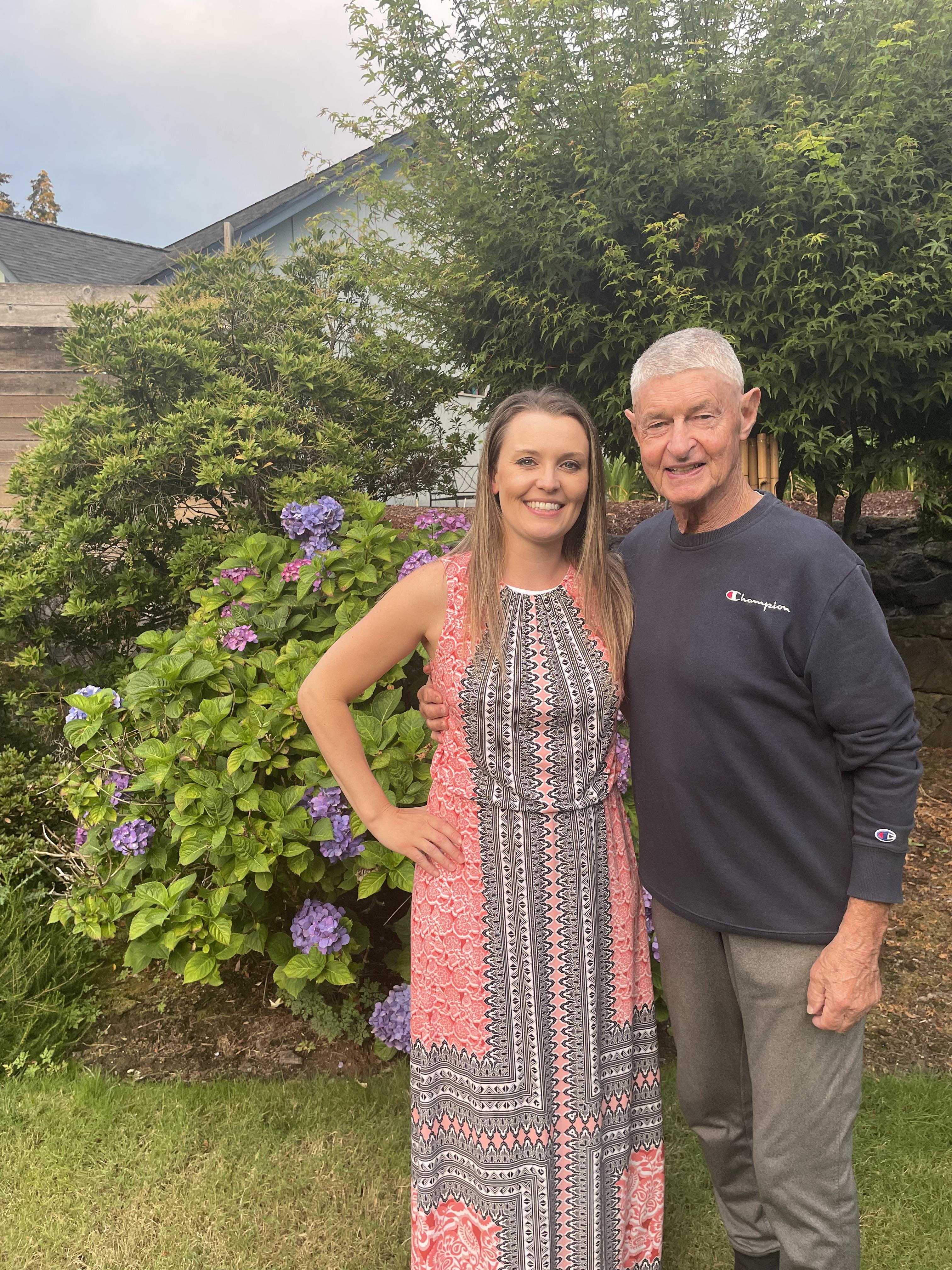 A man and woman standing in front of a bush