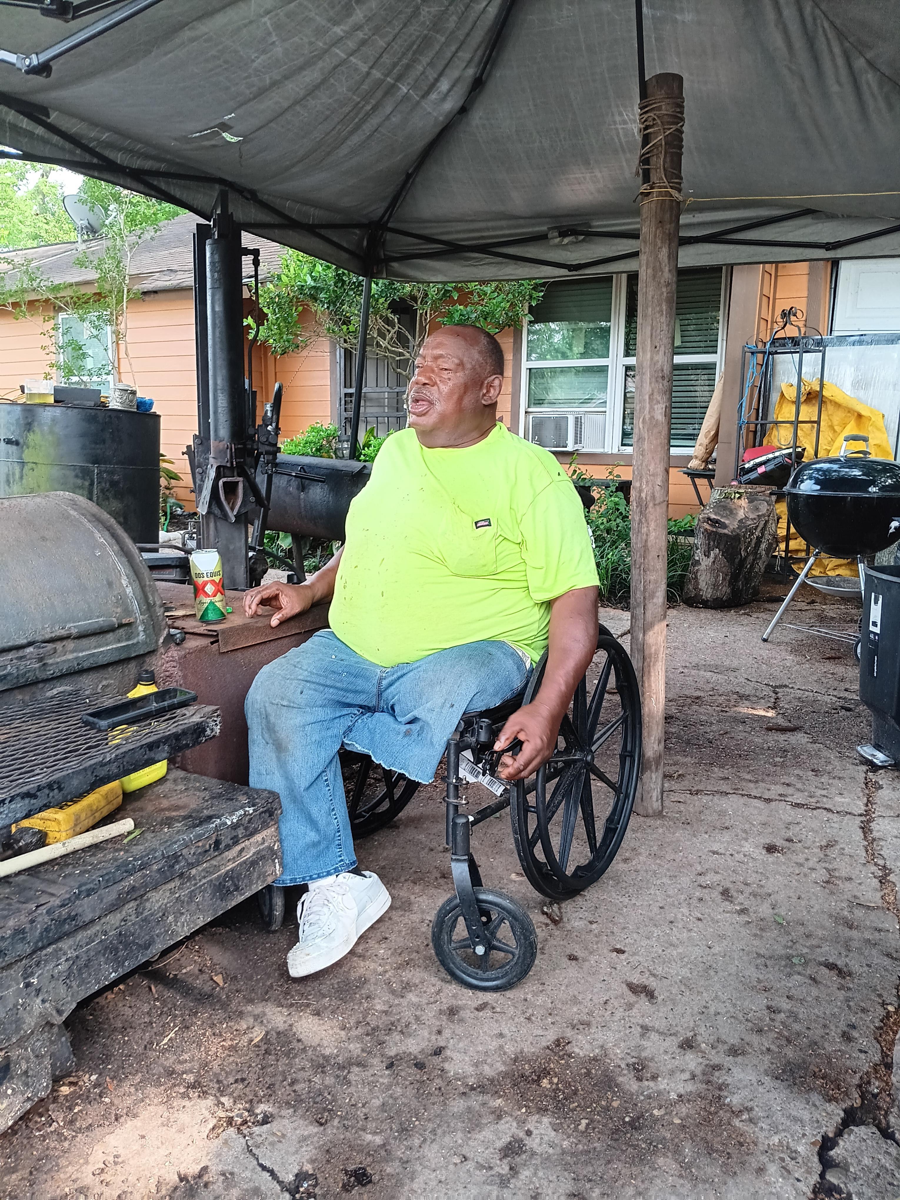 A man sitting in a wheelchair under a canopy