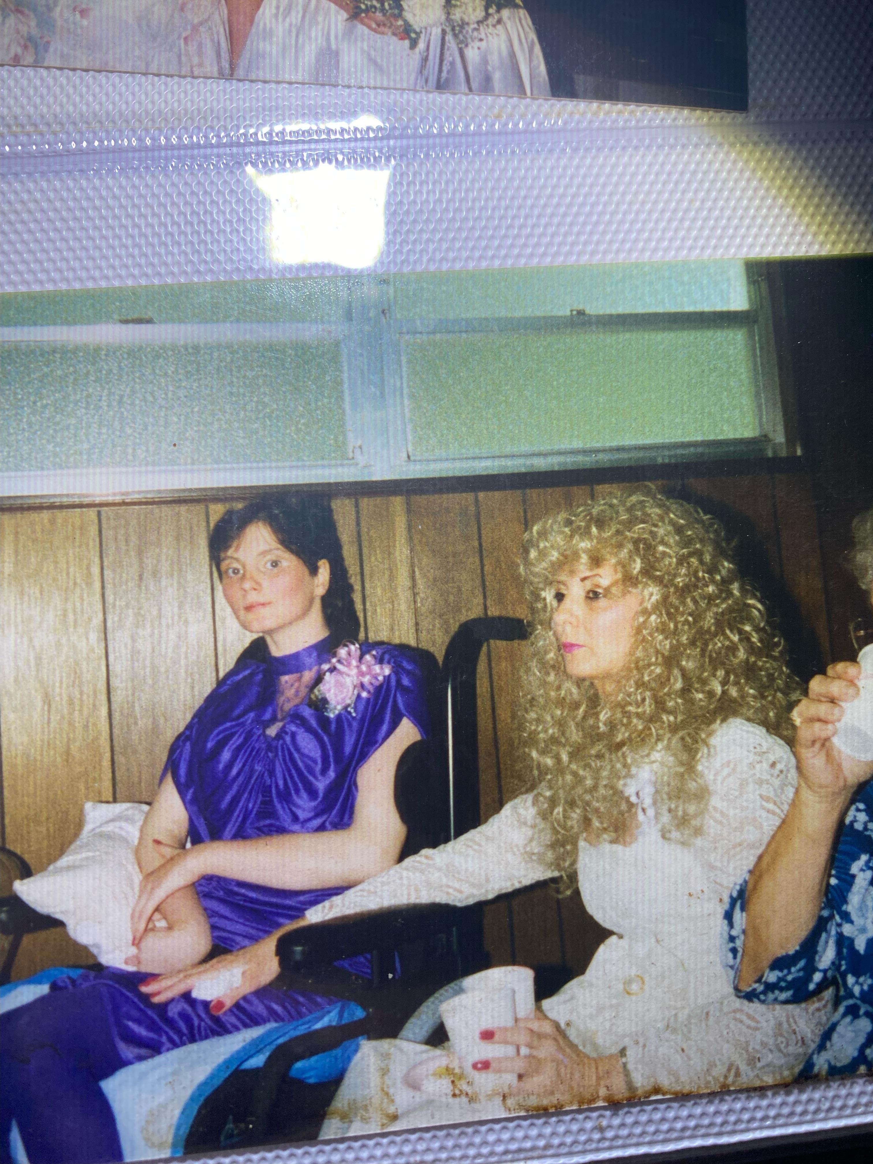 A woman in a blue dress sitting next to a woman in a blue dress
