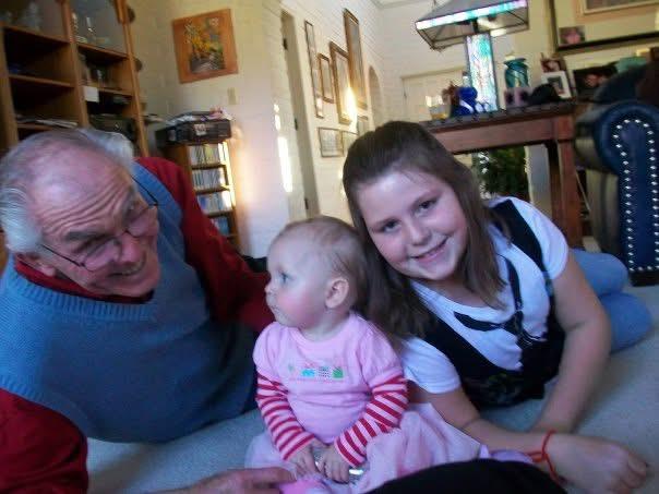 A man and woman sitting on a couch with a baby