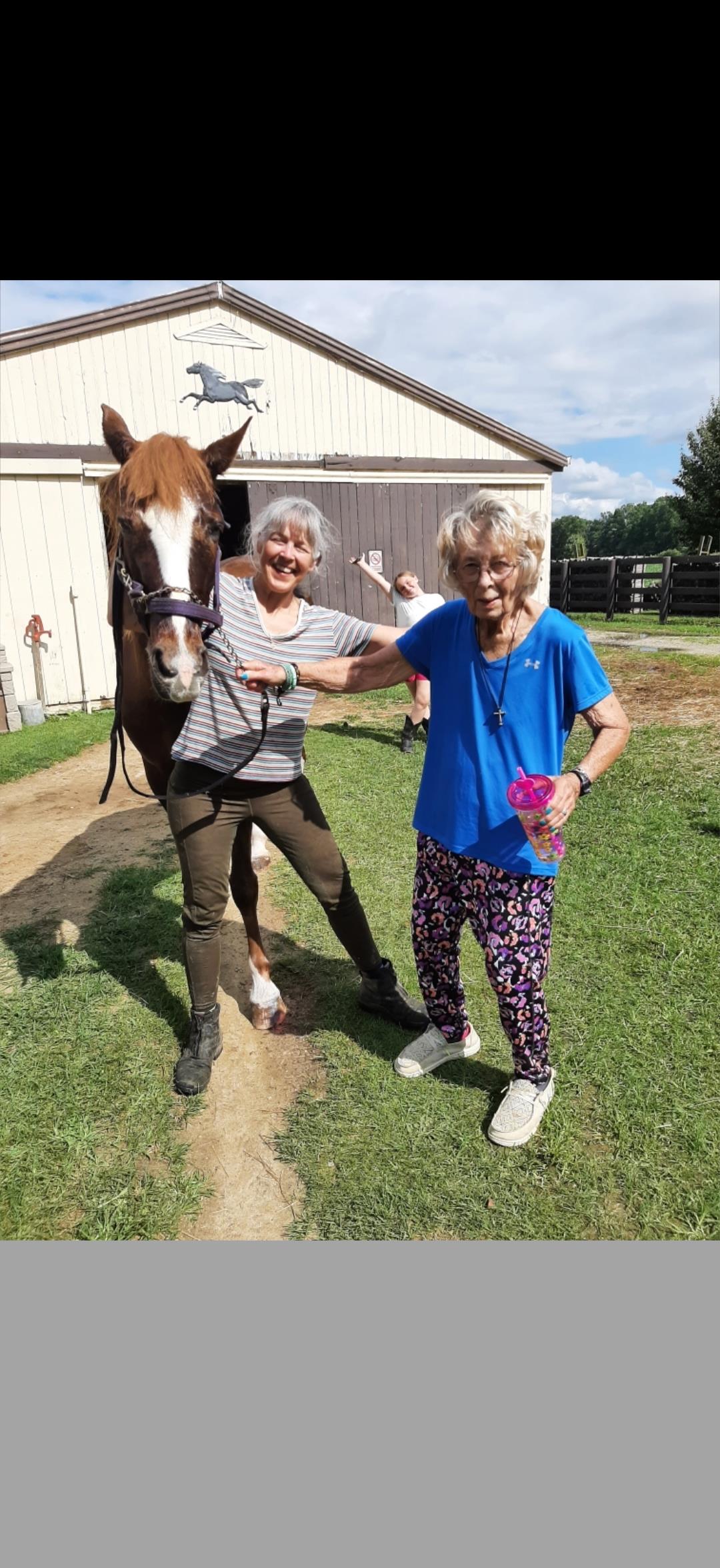 Two women standing next to a horse