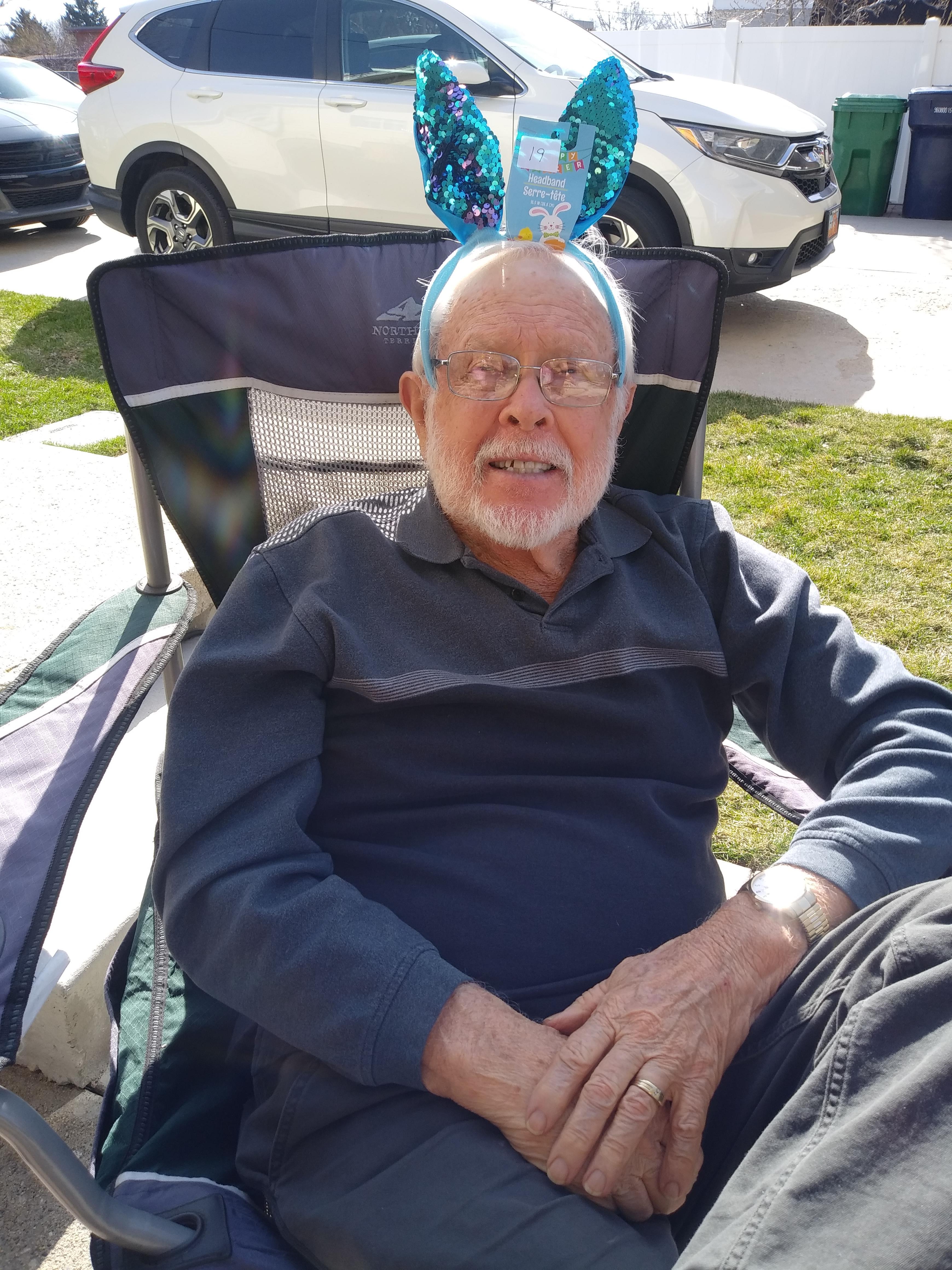A man sitting in a chair with a balloon on his head