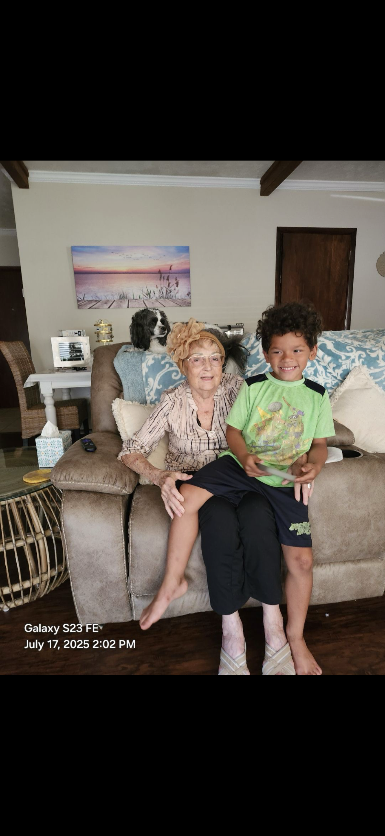 An old woman and a young boy sitting on a couch