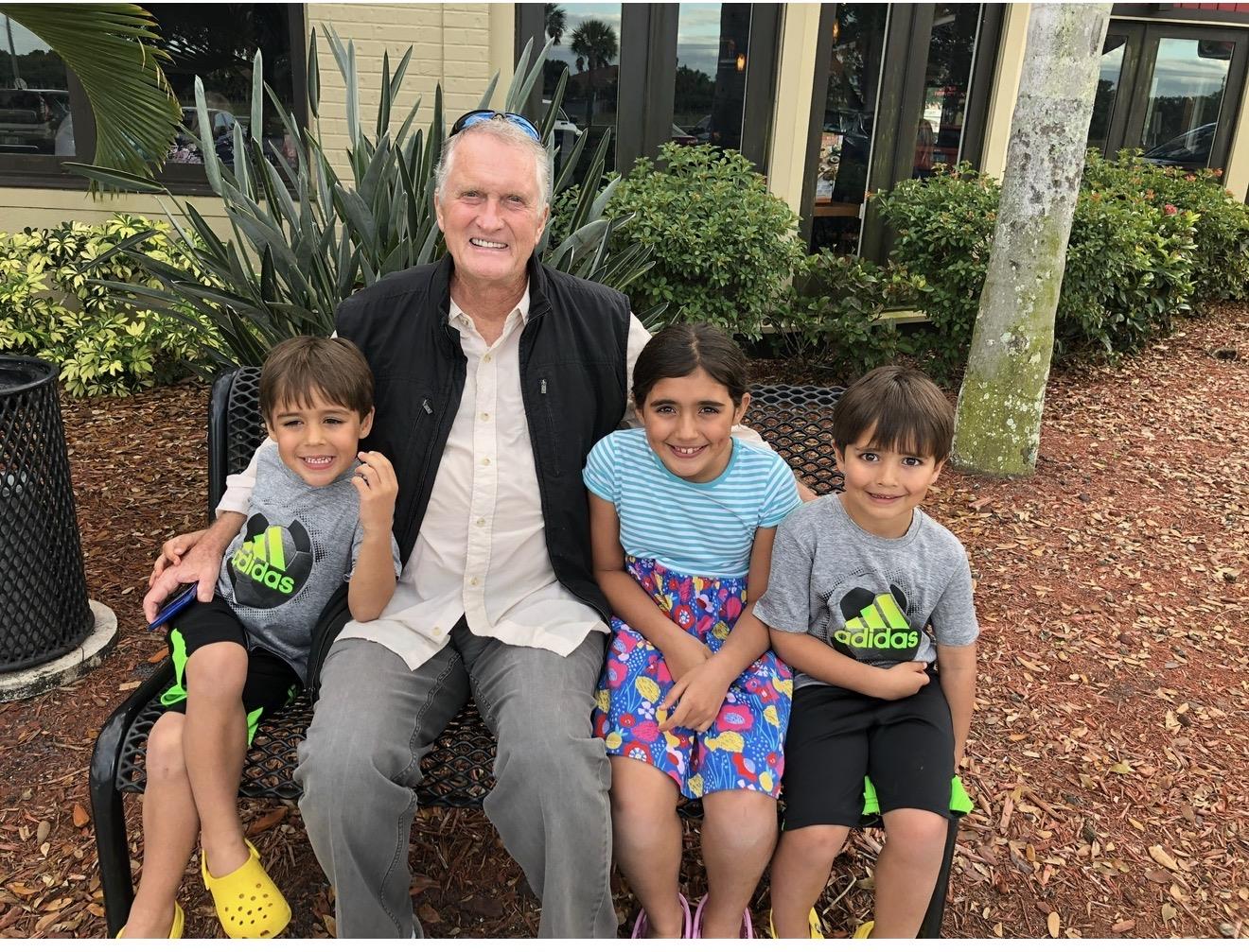 A man sitting on a bench with children
