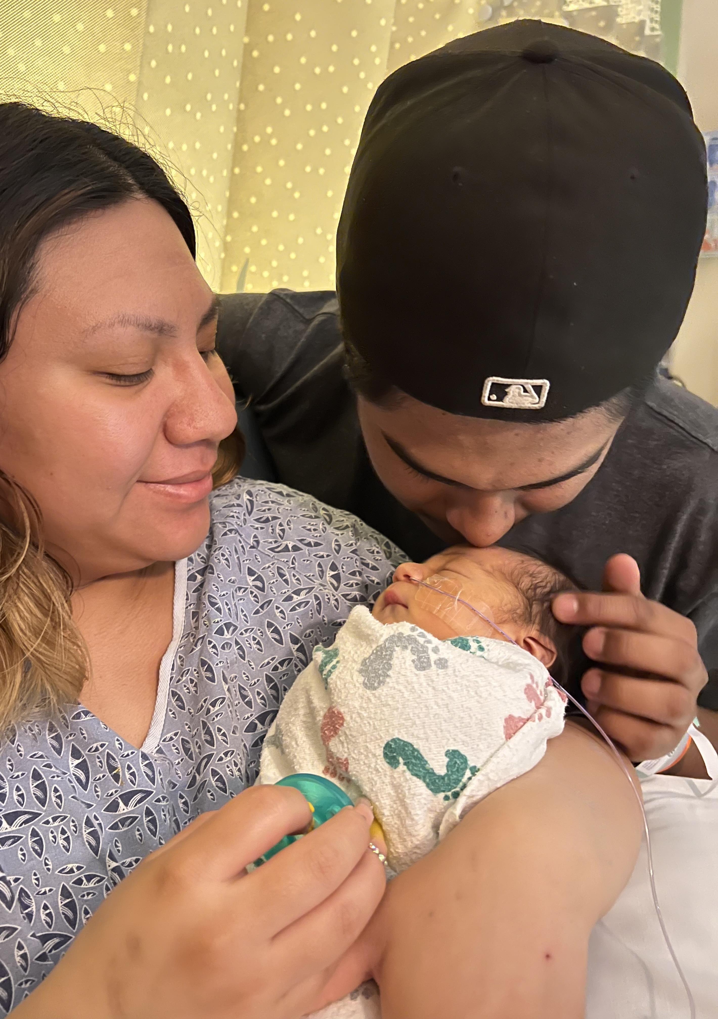 A man and woman holding a baby