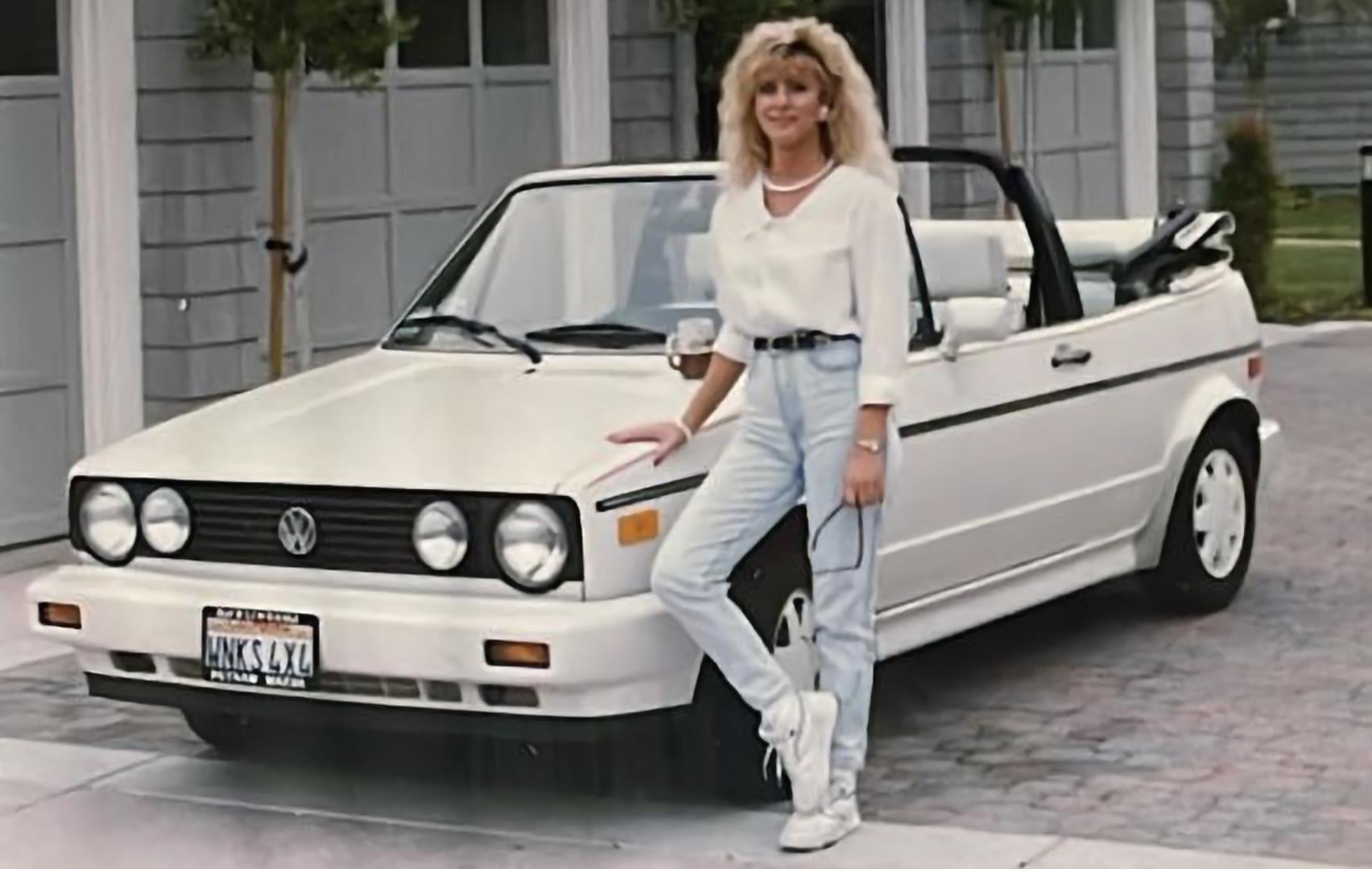 A woman standing next to a car