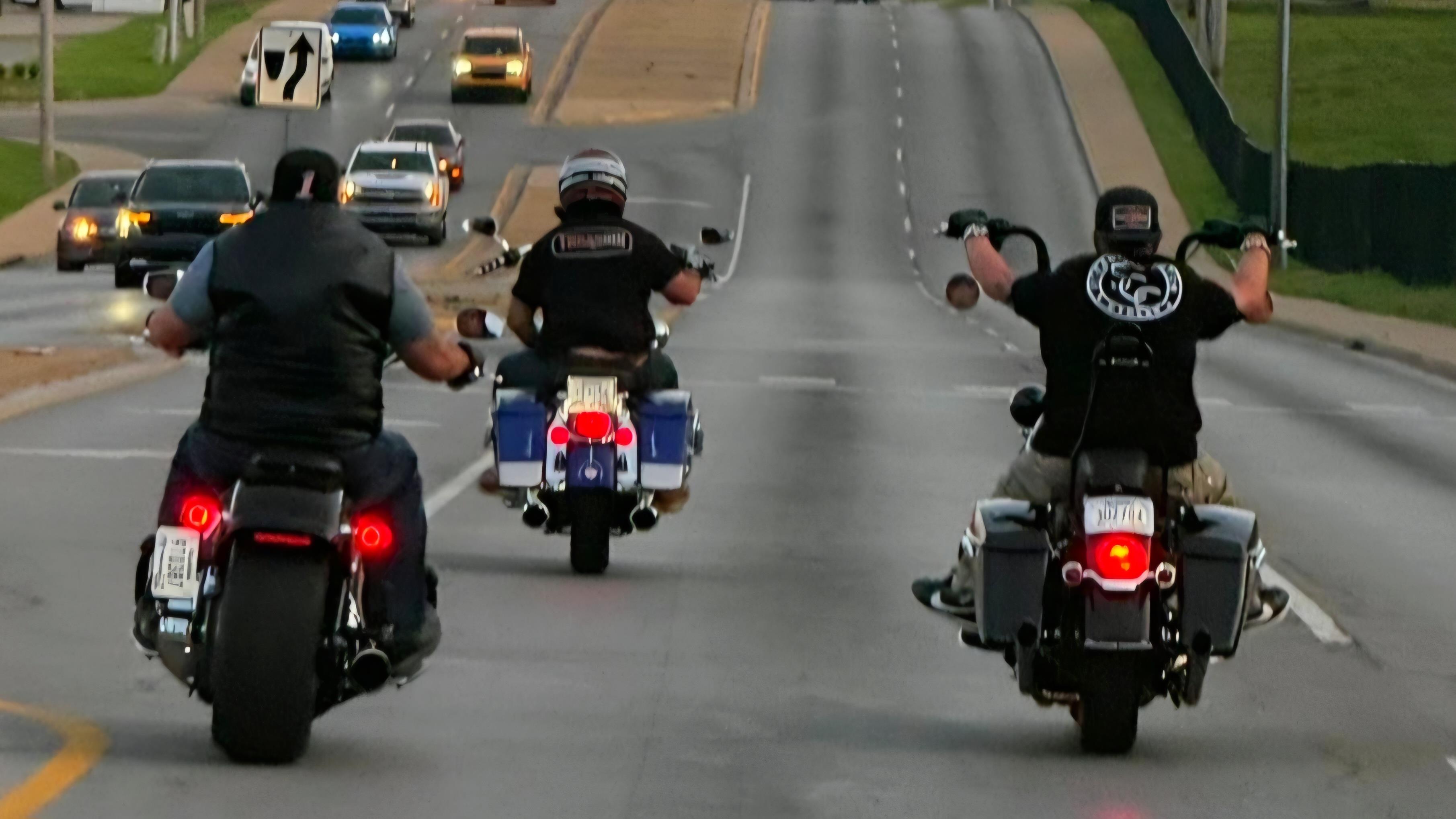 A group of men riding motorcycles on a road